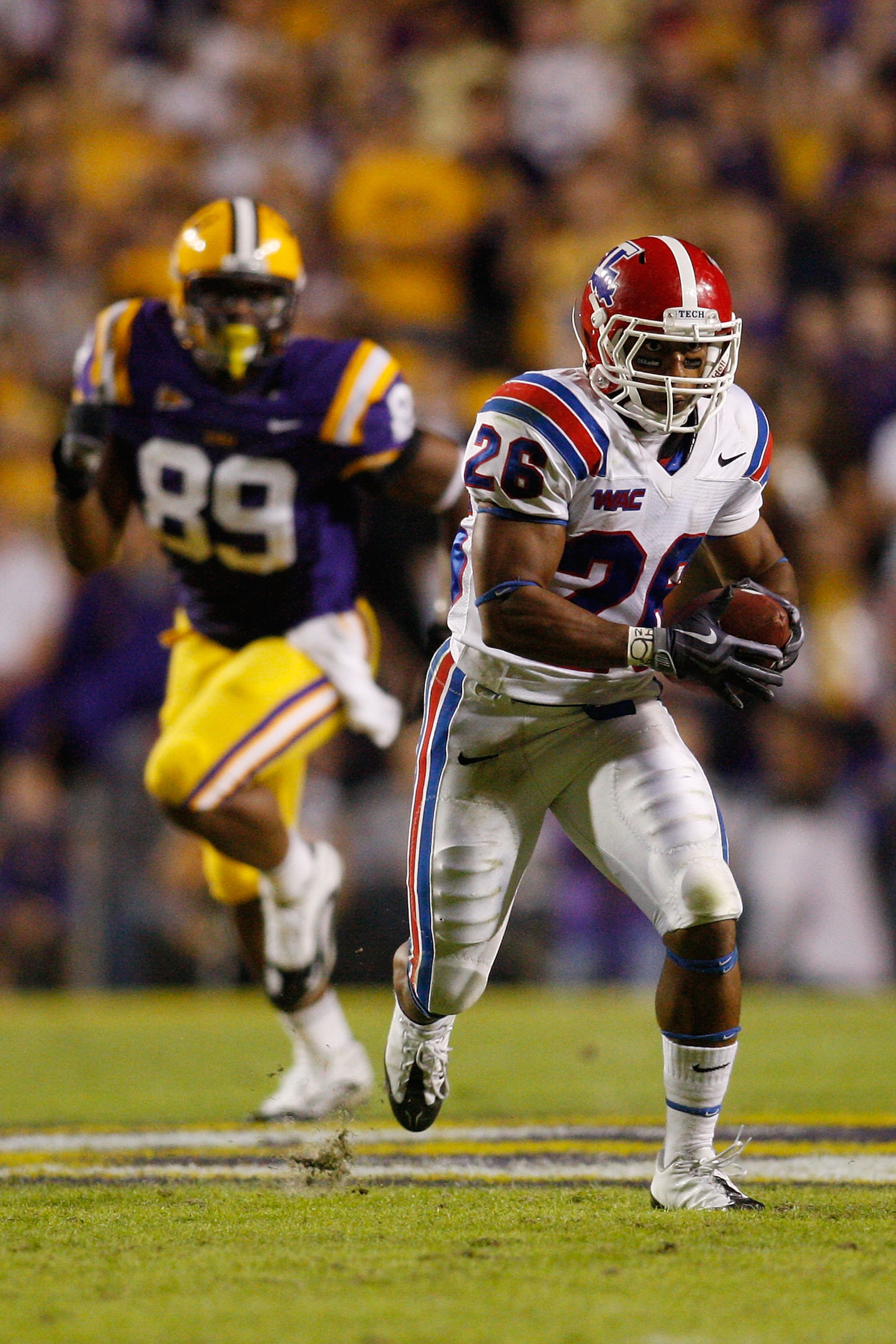 BATON ROUGE, LA - NOVEMBER 14:  Myke Compton #26 of the Louisiana Tech Bulldogs runs past Lavar Edwards #89 of the LSU Tigers at Tiger Stadium on November 14, 2009 in Baton Rouge, Louisiana.  (Photo by Chris Graythen/Getty Images)