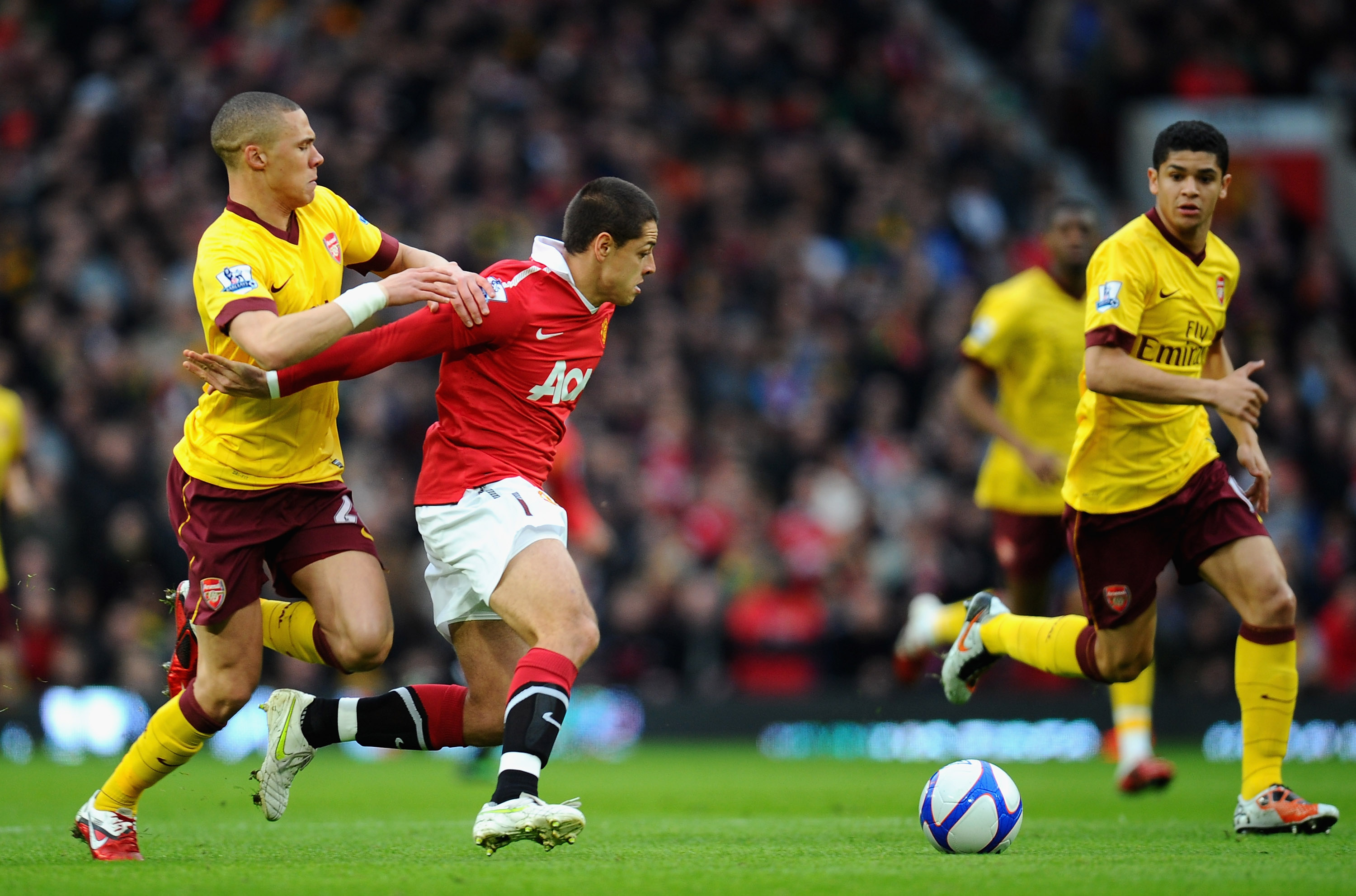 MANCHESTER, ENGLAND - MARCH 12:  Kieran Gibbs of Arsenal tackles Javier Hernandez of Manchester United as Denilson looks on during the FA Cup sponsored by E.On Sixth Round match between Manchester United and Arsenal at Old Trafford on March 12, 2011 in Ma