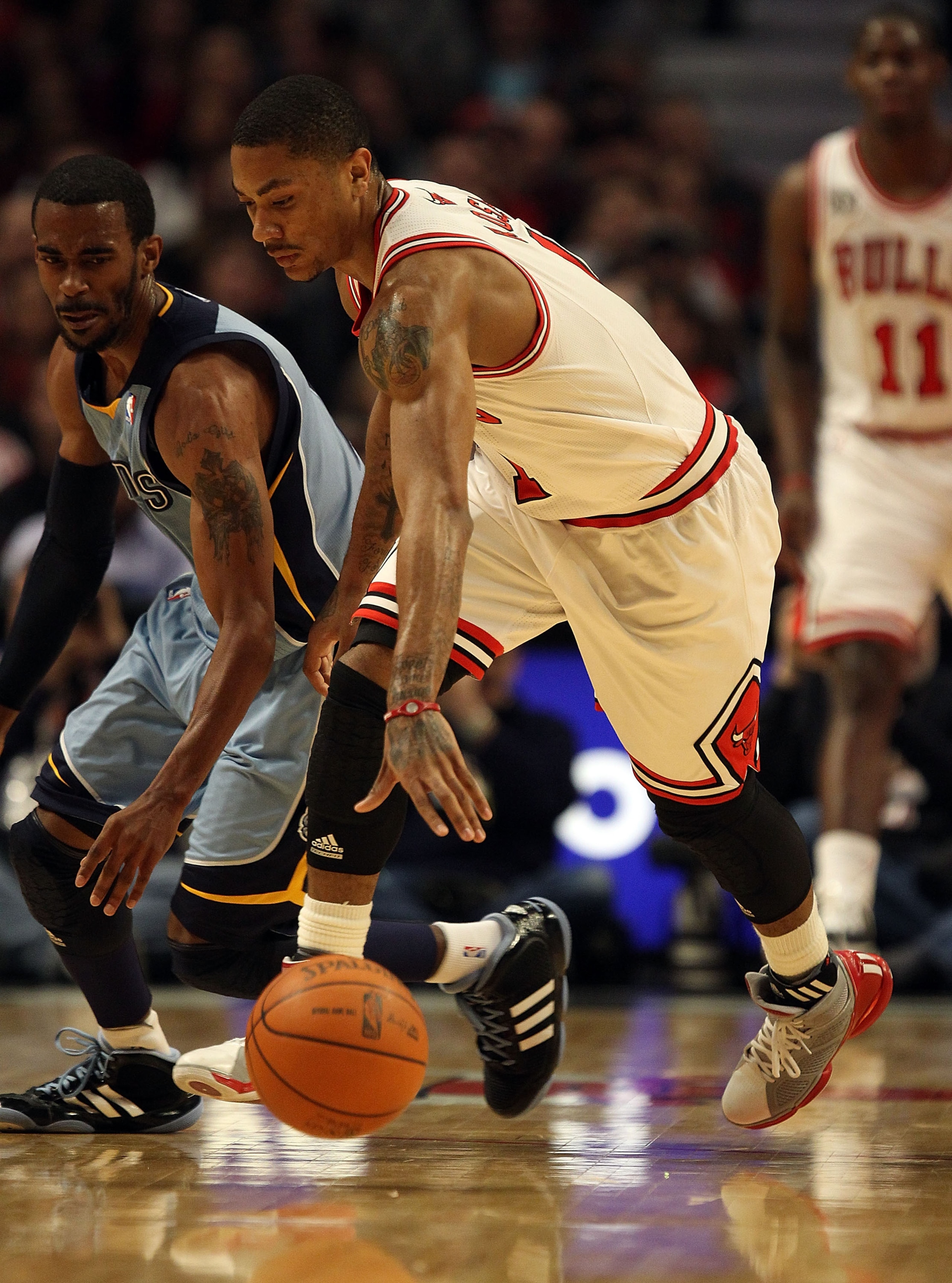 CHICAGO, IL - MARCH 25: Derrick Rose #1 of the Chicago Bulls chases down a loose ball with Mike Conley #11 of the Memphis Grizzlies at the United Center on March 25, 2011 in Chicago, Illinois. The Bulls defeated the Grizzlies 99-96. NOTE TO USER: User exp