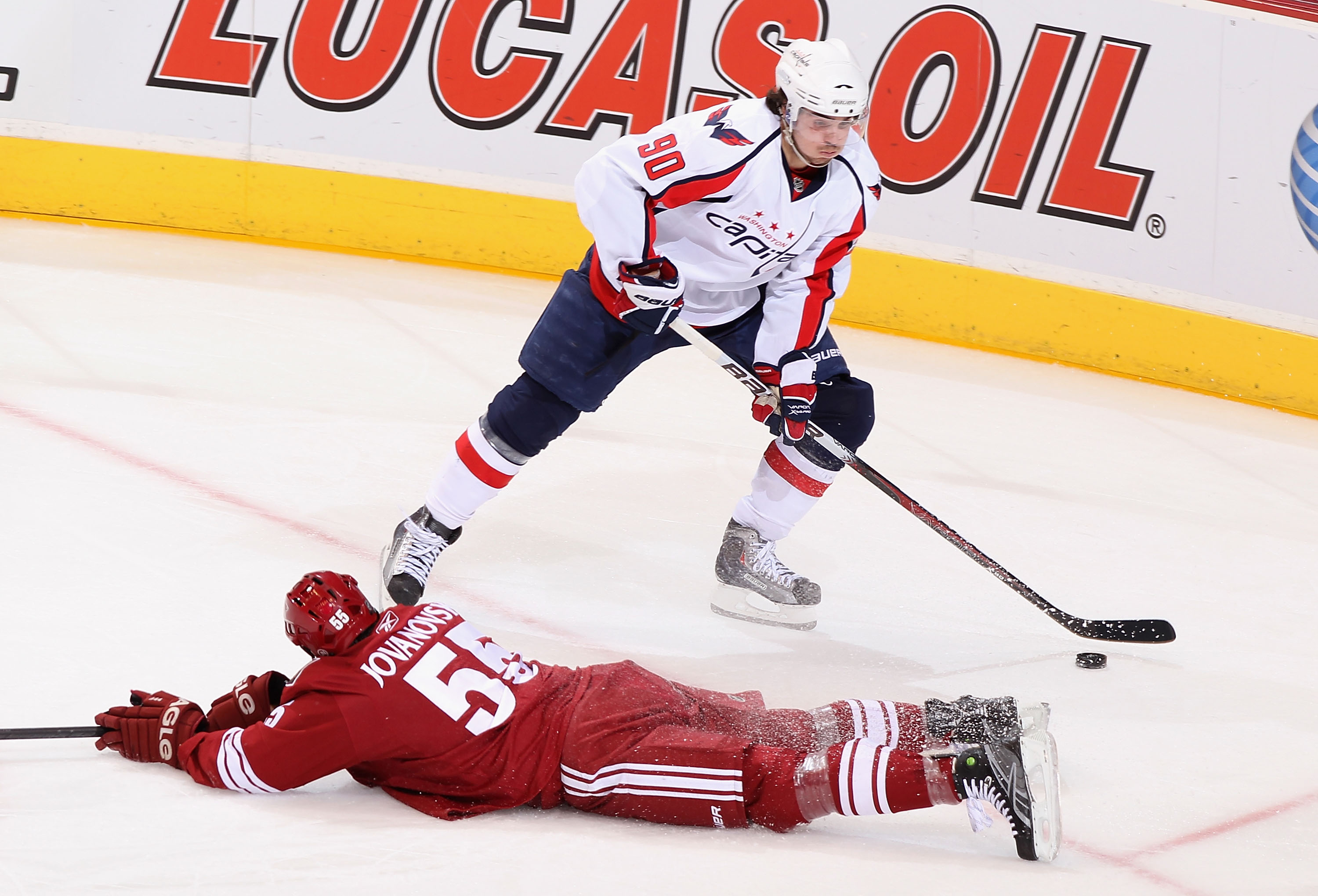 GLENDALE, AZ - FEBRUARY 14:  Marcus Johansson #90 of the Washington Capitals avoids the sliding Ed Jovanovski #55 of the Phoenix Coyotes as he skates in to score during the second period of the NHL game at Jobing.com Arena on February 14, 2011 in Glendale