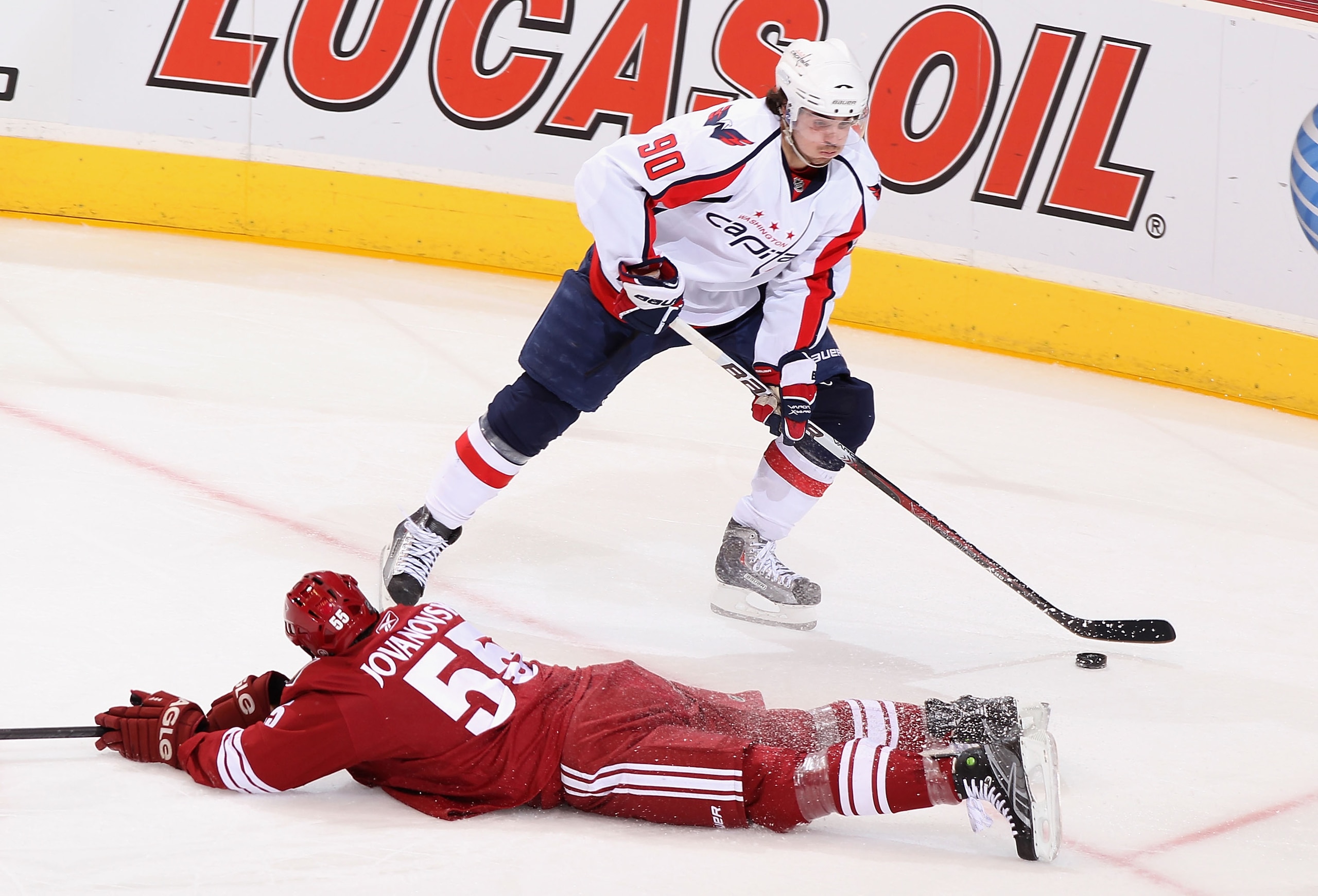 GLENDALE, AZ - FEBRUARY 14:  Marcus Johansson #90 of the Washington Capitals avoids the sliding Ed Jovanovski #55 of the Phoenix Coyotes as he skates in to score during the second period of the NHL game at Jobing.com Arena on February 14, 2011 in Glendale