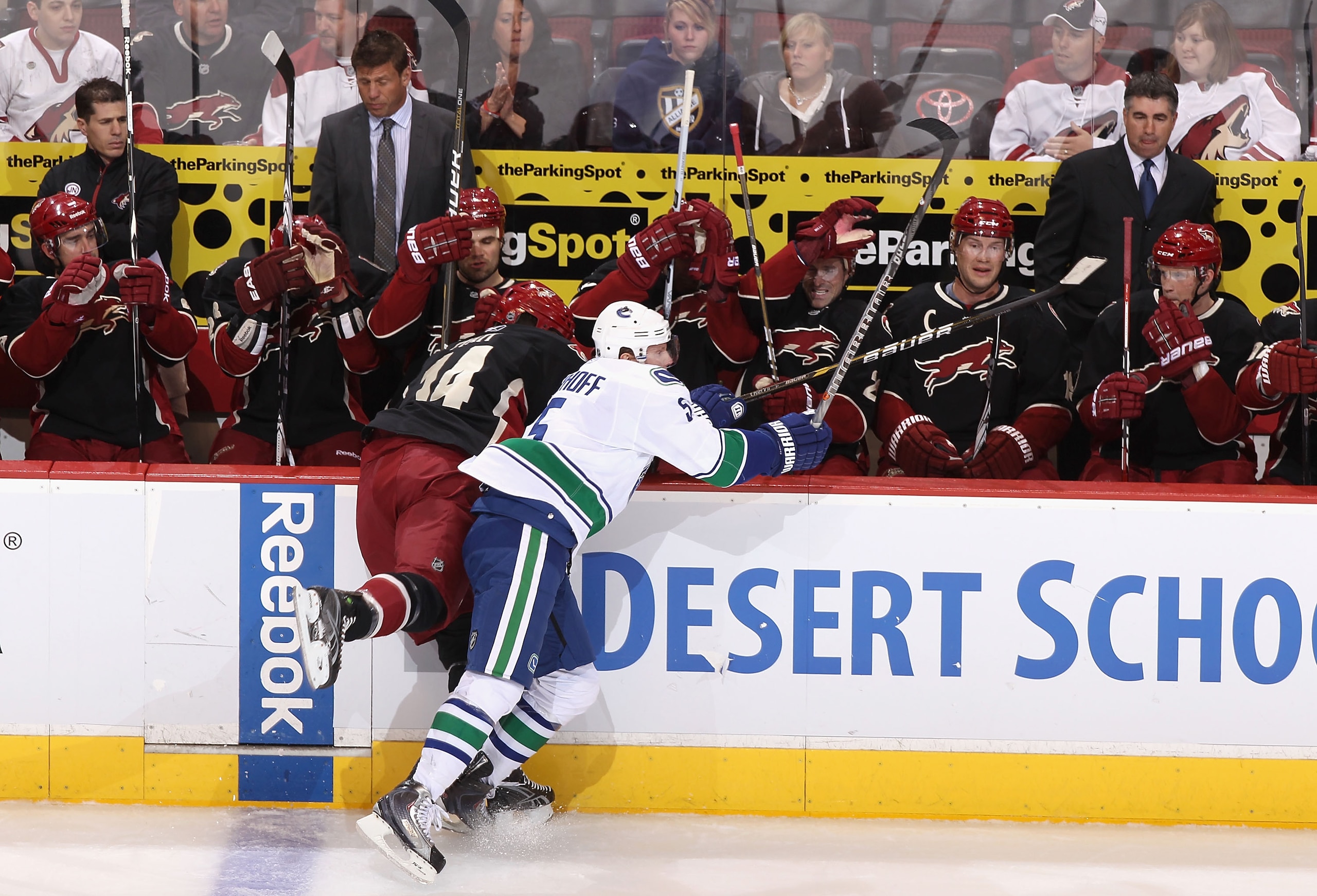 GLENDALE, AZ - MARCH 08:  Christian Ehrhoff #4 of the Vancouver Canucks lays a body check onto Taylor Pyatt #14 of the Phoenix Coyotes during the first period of the NHL game at Jobing.com Arena on March 8, 2011 in Glendale, Arizona.  (Photo by Christian