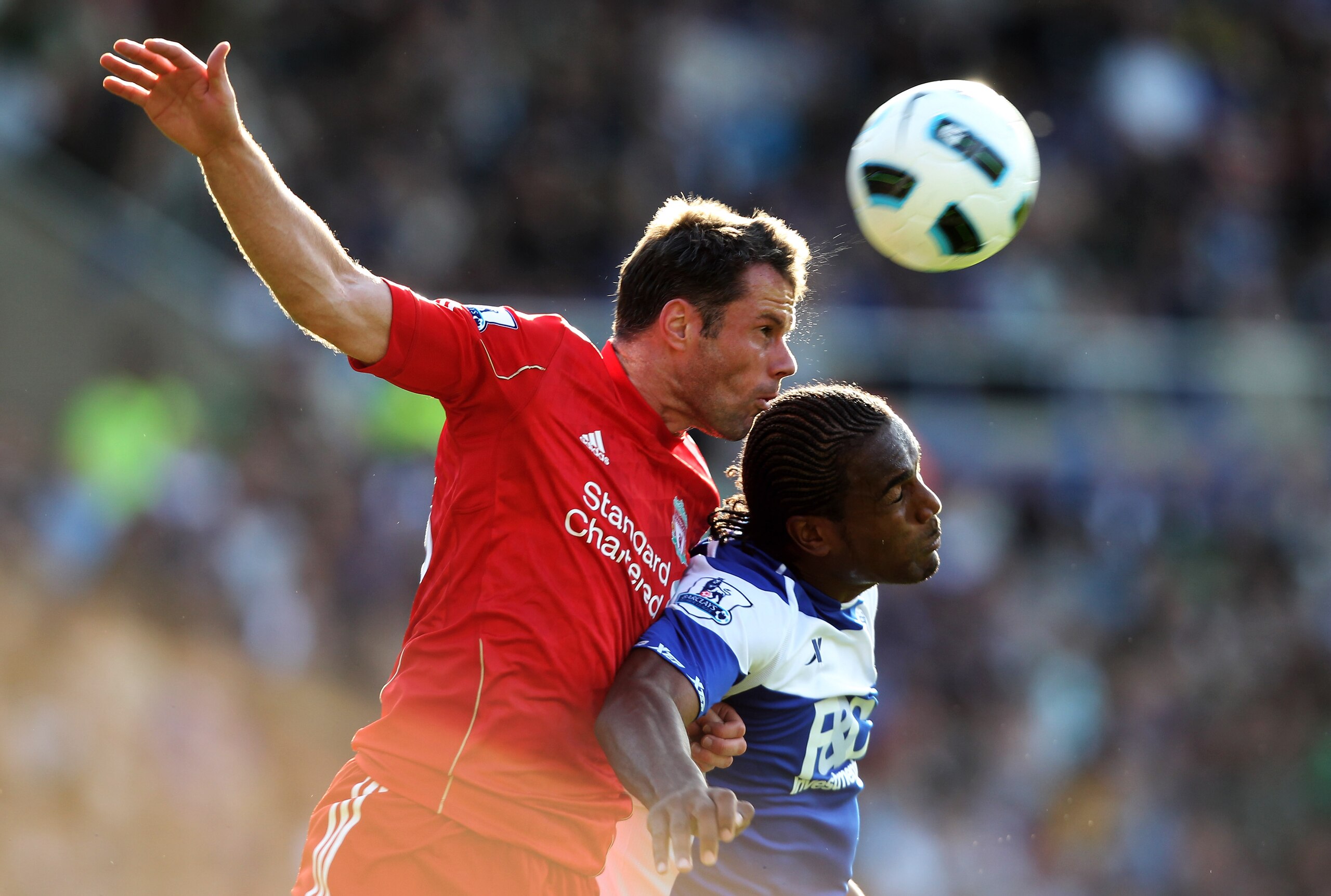 BIRMINGHAM, ENGLAND - SEPTEMBER 12:  Jamie Carragher of Liverpool beats Cameron Jerome of Birmingham City to the ball during the Barclays Premier League match between Birmingham City and Liverpool at St Andrew's Stadium on September 12, 2010 in Birmingham