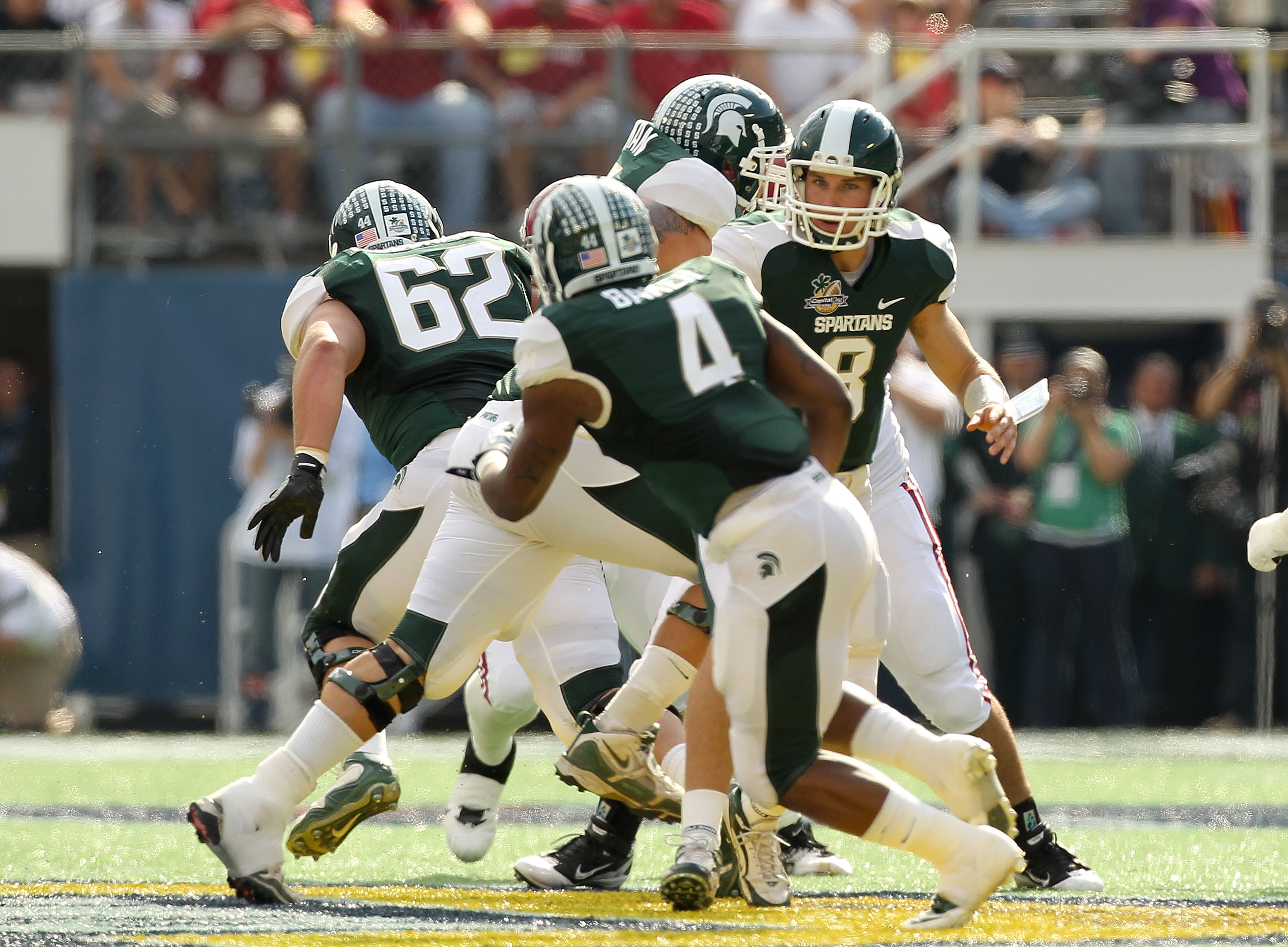 ORLANDO, FL - JANUARY 01:  Kirk Cousins #8 of the Michigan State Spartans hands the ball off to Edwin Baker #4 during the Capitol One Bowl against the Alabama Crimson Tide at the Florida Citrus Bowl on January 1, 2011 in Orlando, Florida.  (Photo by Mike