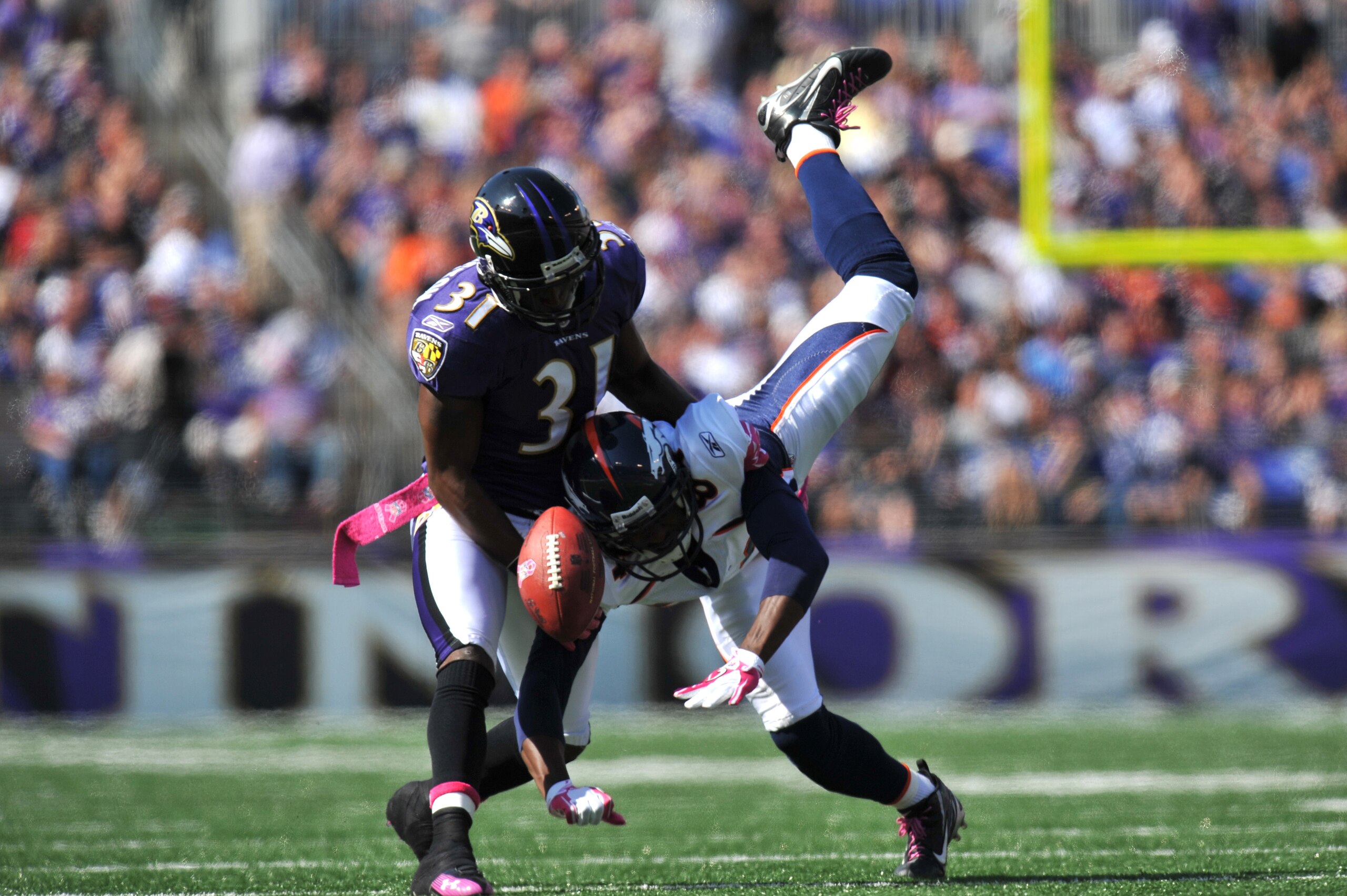 BALTIMORE, MD - OCTOBER 10:  Fabian Washington #31 of the Baltimore Ravens breaks up a pass intended for Brandon Lloyd #84 of the Denver Broncos at M&T Bank Stadium on October 10, 2010 in Baltimore, Maryland. Players wore pink in recognition of Breast Can