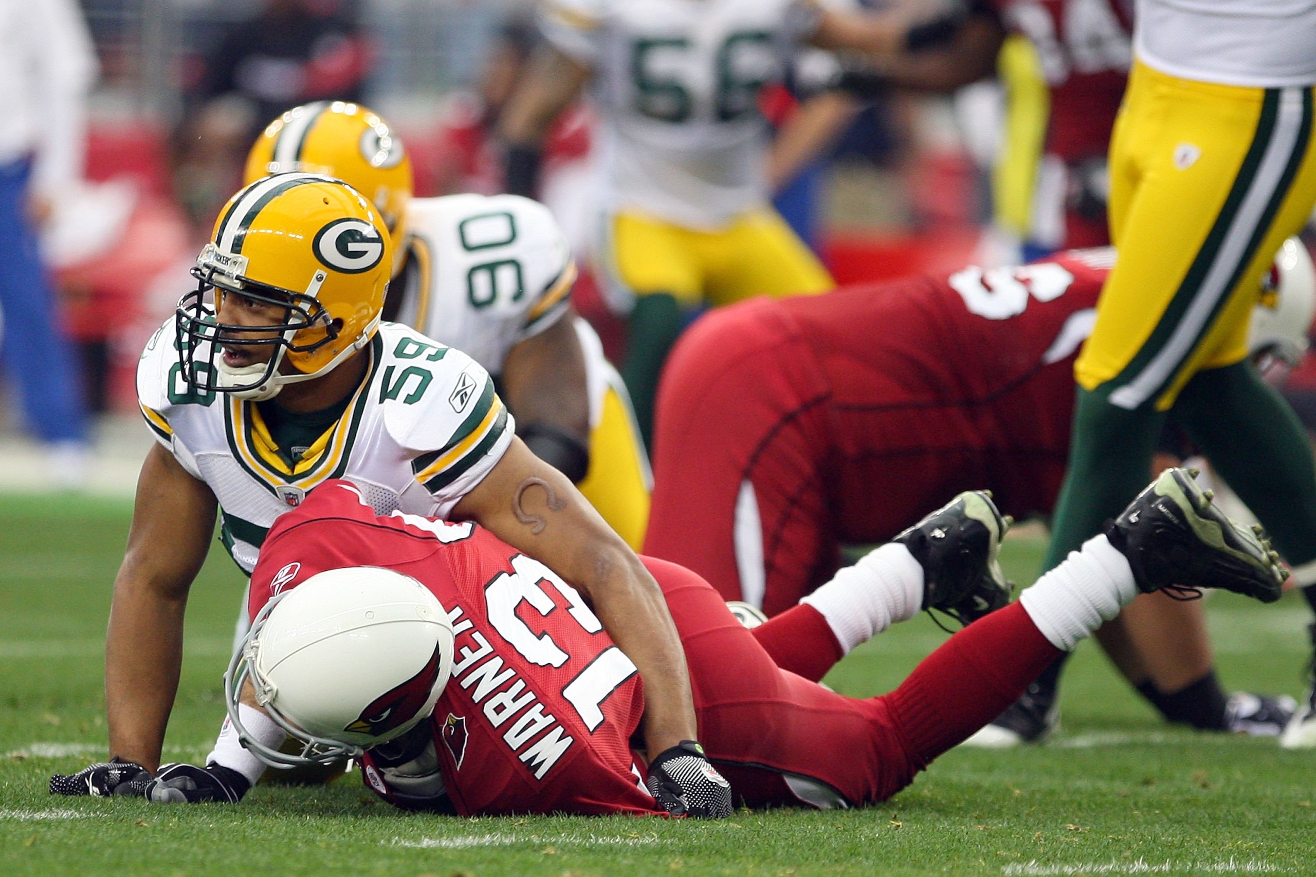 GLENDALE, AZ - JANUARY 03:  Linebacker Brad Jones #59 of the Green Bay Packers looks up after knocking down quarterback Kurt Warner #13 of the Arizona Cardinals at University of Phoenix Stadium on January 3, 2010 in Glendale, Arizona.  (Photo by Maxx Wolf
