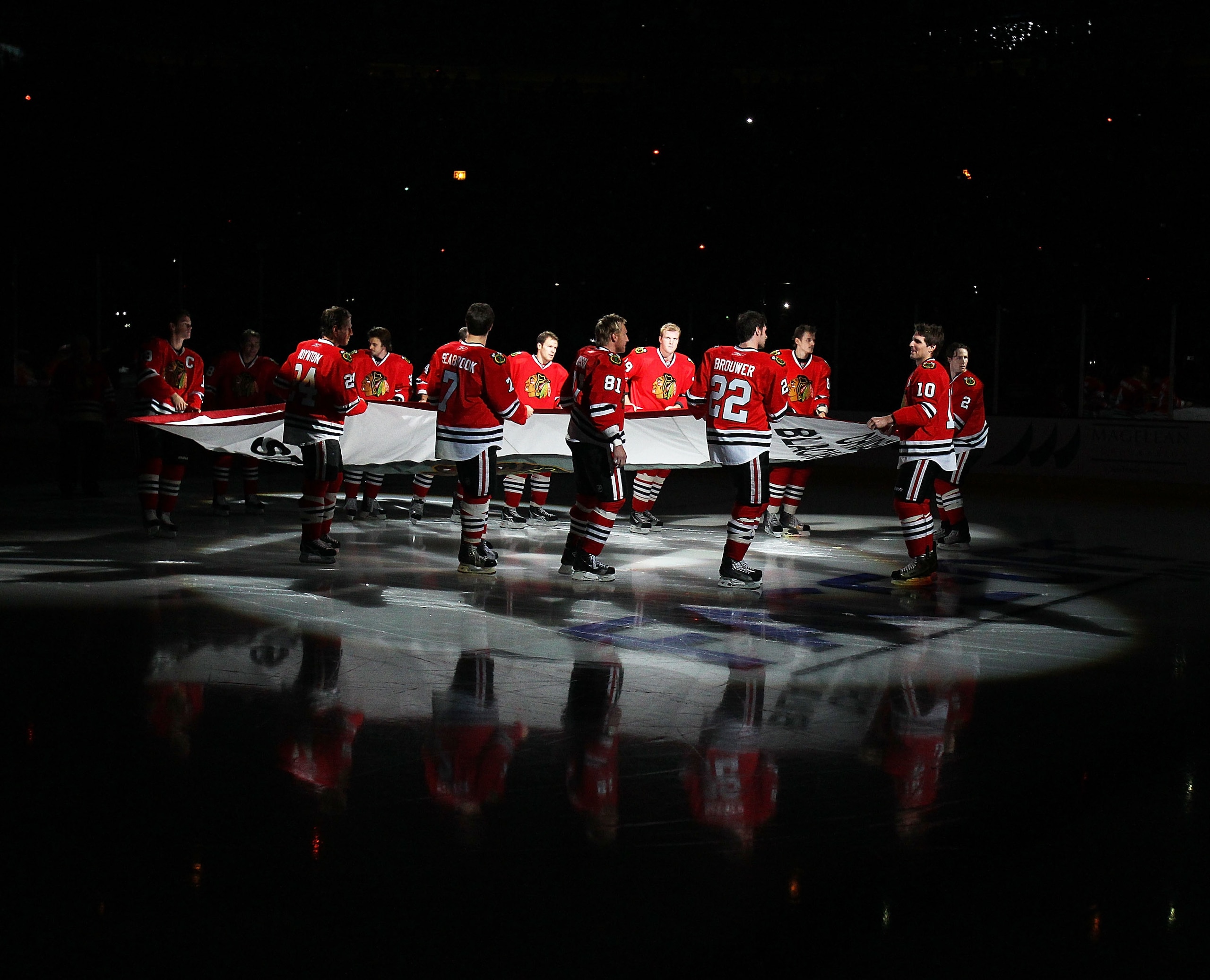 CHICAGO - OCTOBER 09: Members of the Chicago Blackhawks carry the Stanley Cup Championship banner across the ice in a ceremony before the Blackhawks season home opening game against the Detroit Red Wings at the United Center on October 9, 2010 in Chicago,