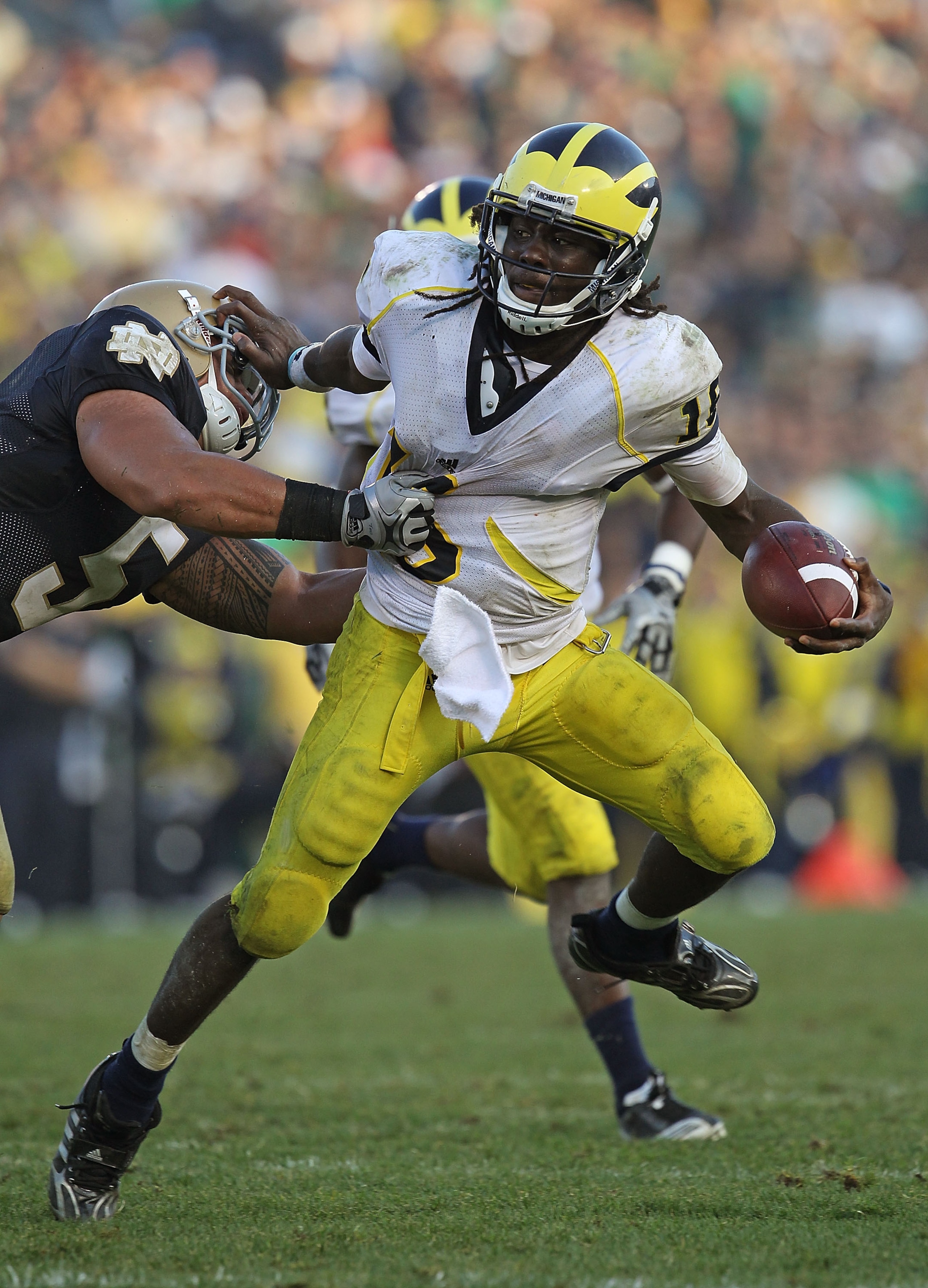 SOUTH BEND, IN - SEPTEMBER 11: Denard Robinson #16 of the Michigan Wolverines pushes off a tackle attempt by Manti Te'o #5 of the Notre Dame Fighting Irish in the final minute at Notre Dame Stadium on September 11, 2010 in South Bend, Indiana. Michigan de