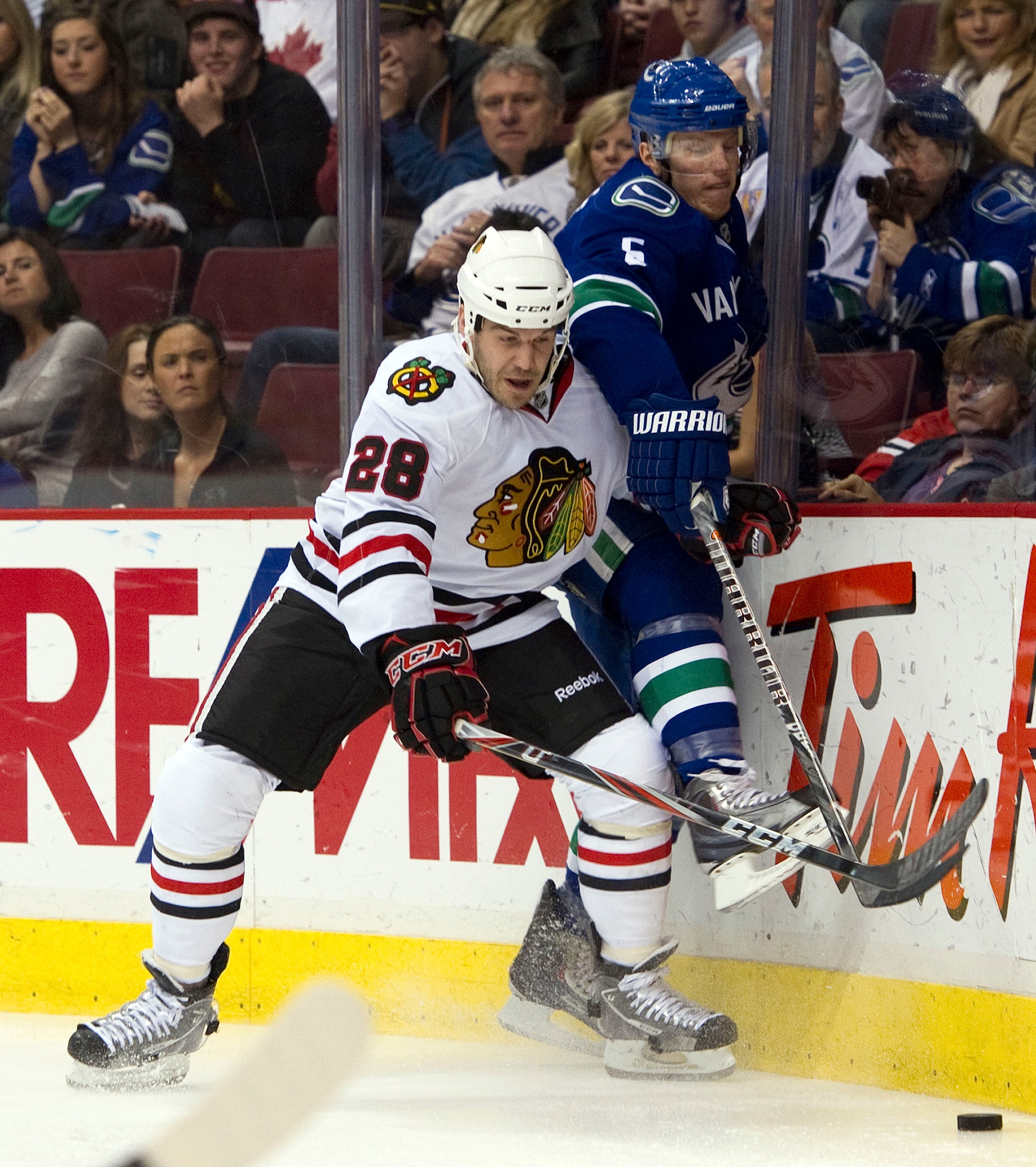 VANCOUVER, CANADA - FEBRUARY 4: Jake Dowell #28 of the Chicago Blackhawks pins Christian Ehrhoff #5 of the Vancouver Canucks up against the end boards during the first period in NHL action on February 04, 2011 at Rogers Arena in Vancouver, British Columbi VANCOUVER, CANADA - FEBRUARY 4: Jake Dowell #28 of the Chicago Blackhawks pins Christian Ehrhoff #5 of the Vancouver Canucks up against the end boards during the first period in NHL action on February 04, 2011 at Rogers Arena in Vancouver, British Columbi