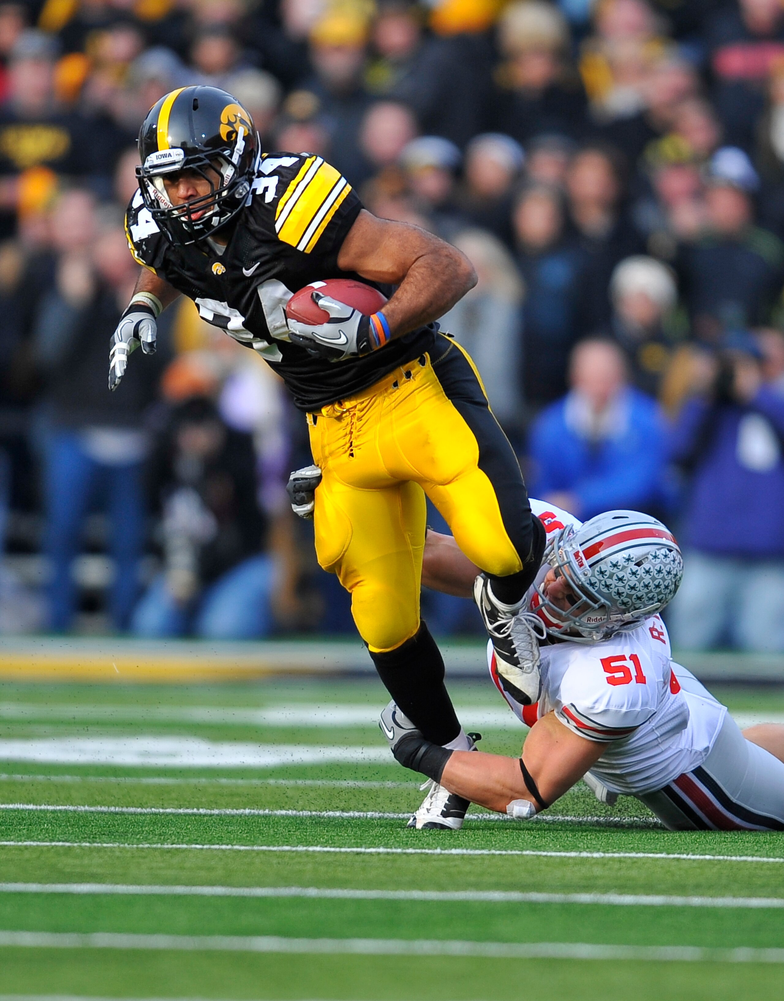IOWA CITY, IA - NOVEMBER 20: Running back Marcus Coker #34 of the University of Iowa Hawkeyes is tackled by linebacker Ross Homan #51 of the Ohio State Buckeyes during the first half of play at Kinnick Stadium on November 20, 2010 in Iowa City, Iowa. Ohi IOWA CITY, IA - NOVEMBER 20: Running back Marcus Coker #34 of the University of Iowa Hawkeyes is tackled by linebacker Ross Homan #51 of the Ohio State Buckeyes during the first half of play at Kinnick Stadium on November 20, 2010 in Iowa City, Iowa. Ohi