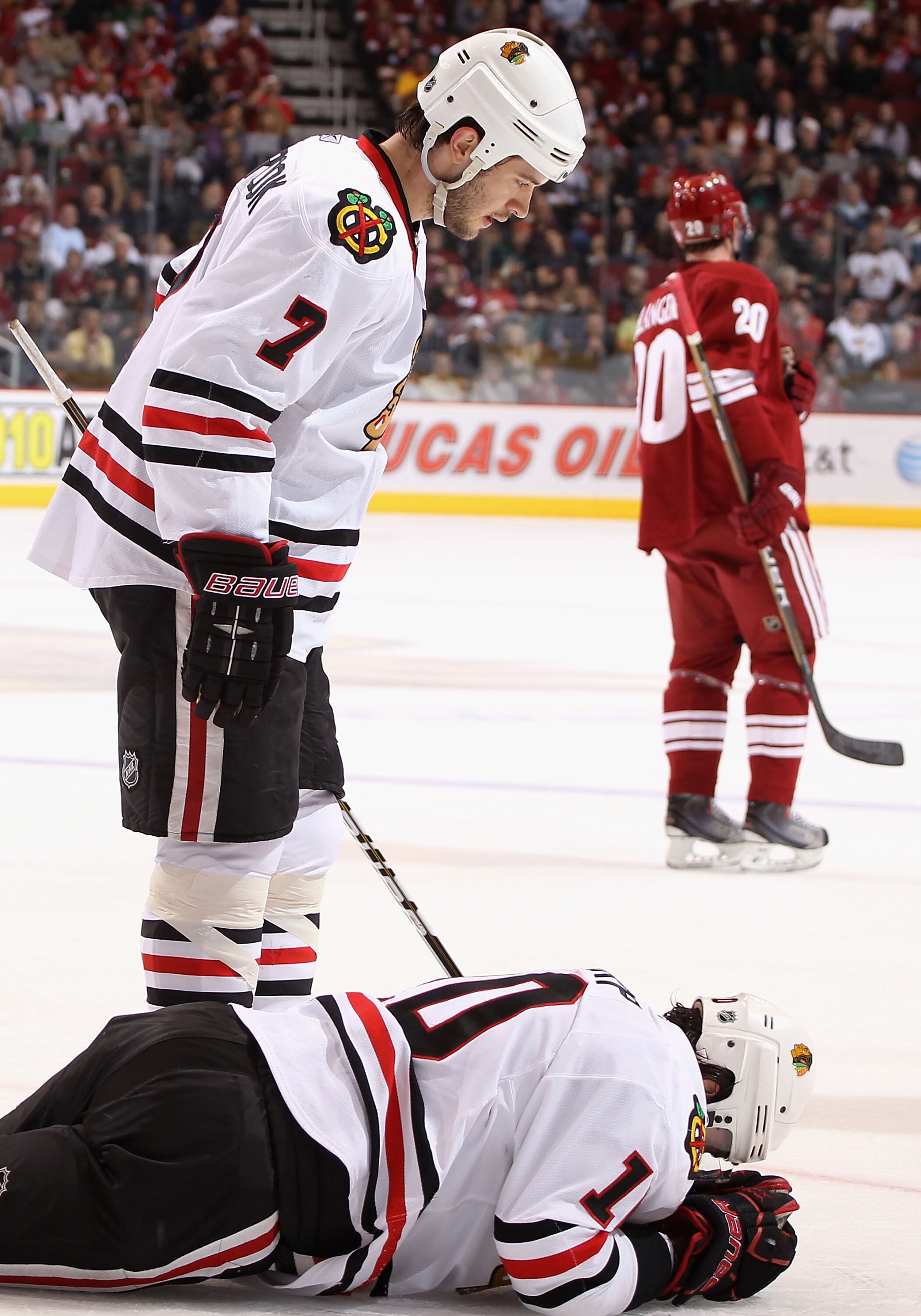 GLENDALE, AZ - MARCH 20:  Patrick Sharp #10 of the Chicago Blackhawks lays on the ice after an injury as Brent Seabrook #7 looks down during the first period of the NHL game against the Phoenix Coyotes at Jobing.com Arena on March 20, 2011 in Glendale, Ar
