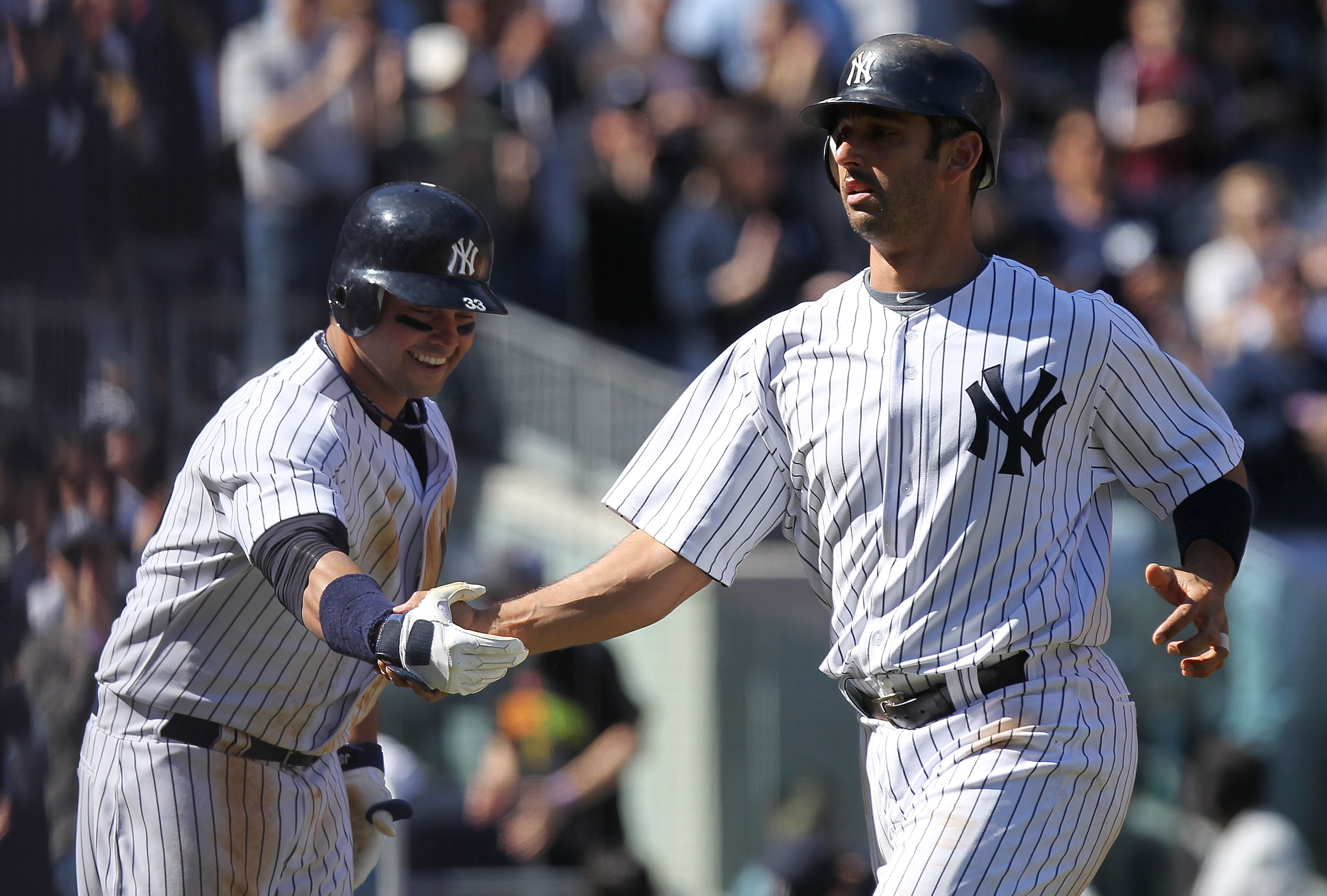 NEW YORK, NY - APRIL 03:  Jorge Posada #20 of the New York Yankees celebrates his second homerun with scoring runner Nick Swisher #33 against the Detroit Tigers at Yankee Stadium on April 3, 2011 in the Bronx borough of New York City.  (Photo by Nick Laha