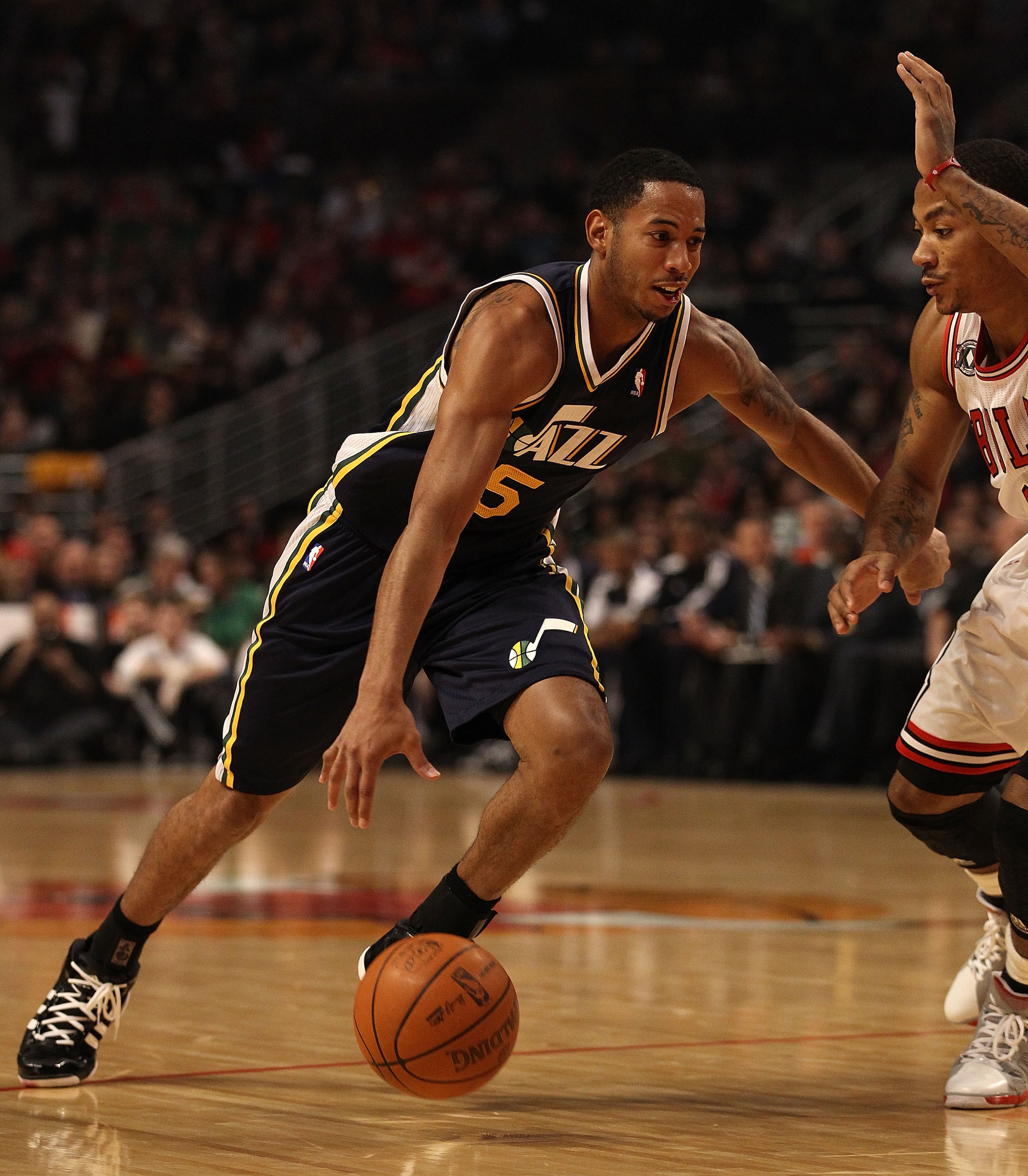 CHICAGO, IL - MARCH 12: Devin Harris #5 of the Utah Jazz drives against Derrick Rose #1 of the Chicago Bulls at the United Center on March 12, 2011 in Chicago, Illinois. The Bulls defeated the Jazz 118-100. NOTE TO USER: User expressly acknowledges and ag CHICAGO, IL - MARCH 12: Devin Harris #5 of the Utah Jazz drives against Derrick Rose #1 of the Chicago Bulls at the United Center on March 12, 2011 in Chicago, Illinois. The Bulls defeated the Jazz 118-100. NOTE TO USER: User expressly acknowledges and ag