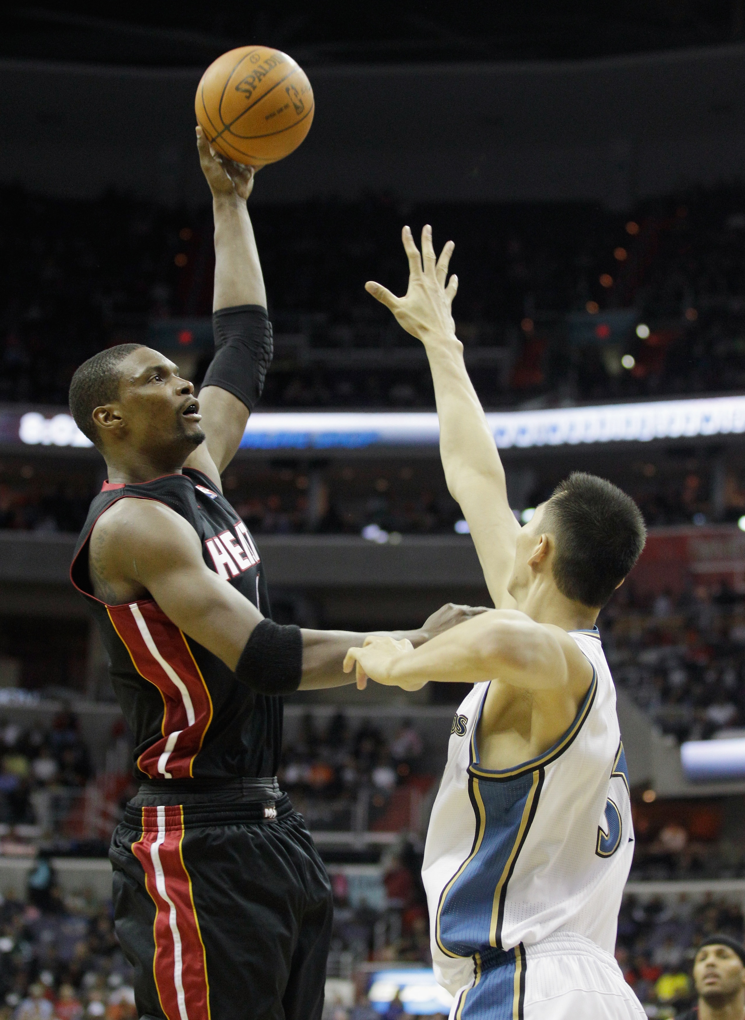 WASHINGTON, DC - MARCH 30:  Chris Bosh #1 of the Miami Heat shoots over Yi Jianlian #31 of the Washington Wizards during the first half at the Verizon Center on March 30, 2011 in Washington, DC. NOTE TO USER: User expressly acknowledges and agrees that, b