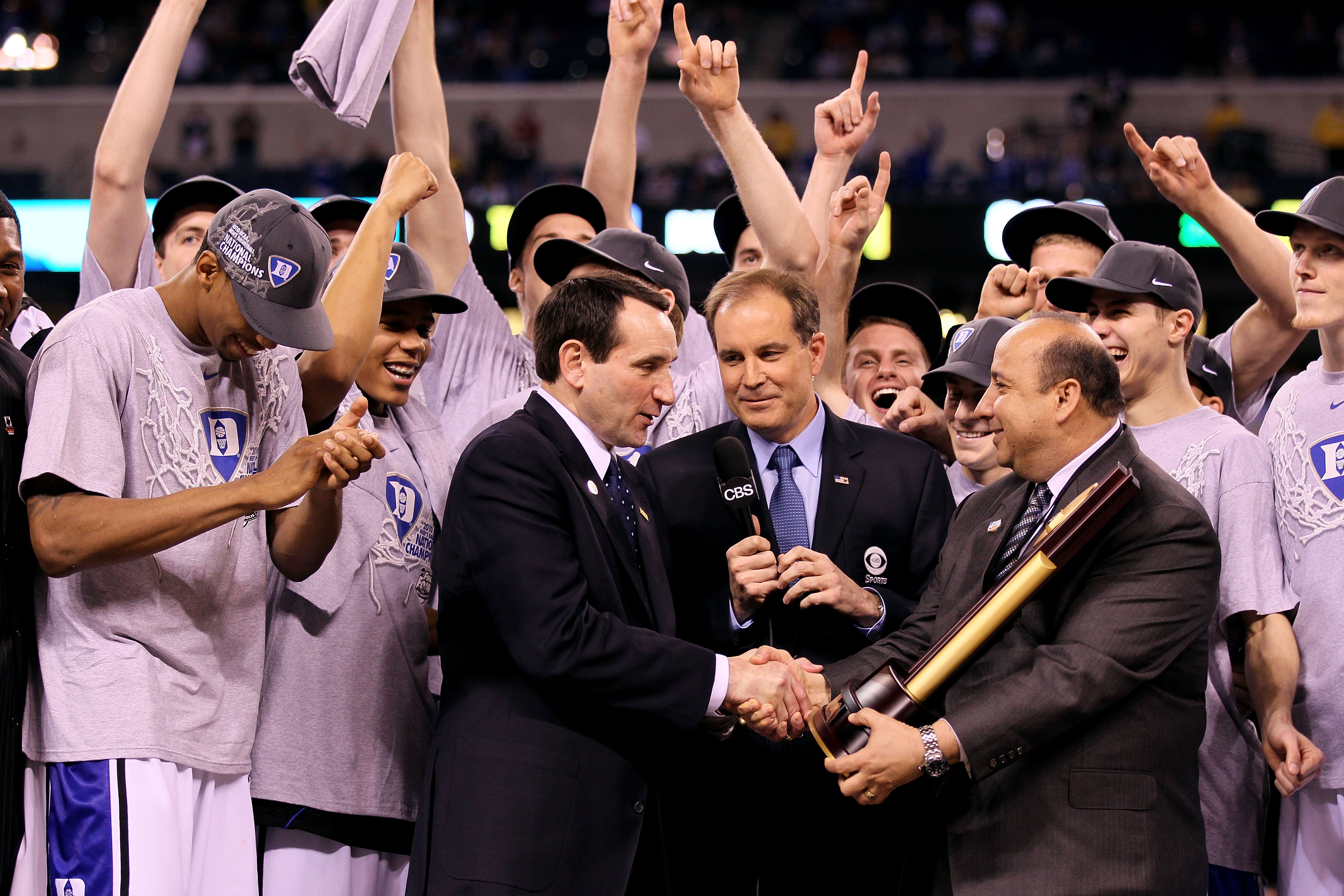 INDIANAPOLIS - APRIL 05: Head coach Mike Krzyzewski of the Duke Blue Devils receives the trophy as his players celebrate after they won 61-59 against the Butler Bulldogs during the 2010 NCAA Division I Men's Basketball National Championship game at Lucas