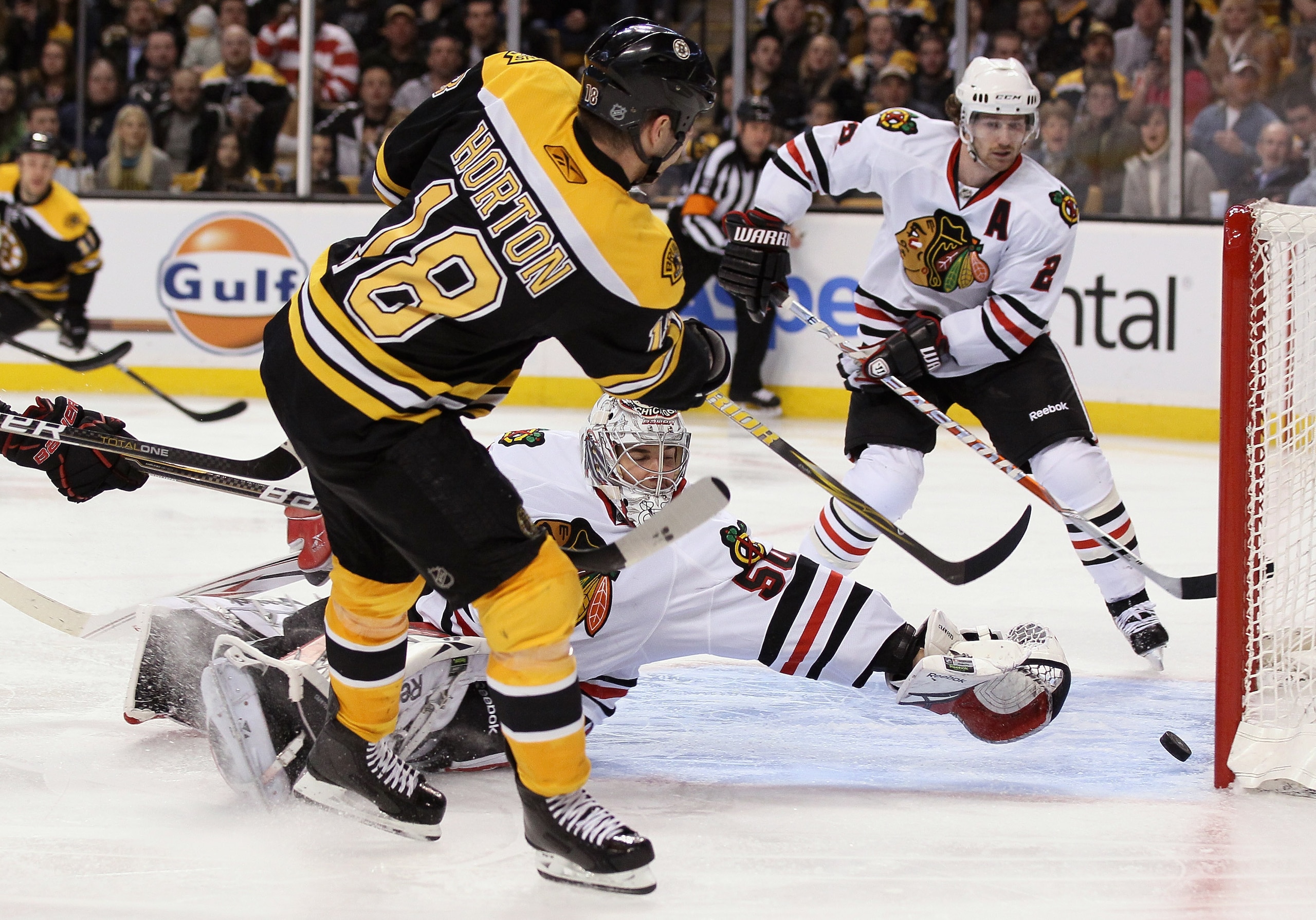 BOSTON, MA - MARCH 29:  Nathan Horton #18 of the Boston Bruins gets the puck past Corey Crawford #50 of the Chicago Blackhawks in the third period on March 29, 2011 at the TD Garden in Boston, Massachusetts. The Boston Bruins defeated the Chicago Blackhaw