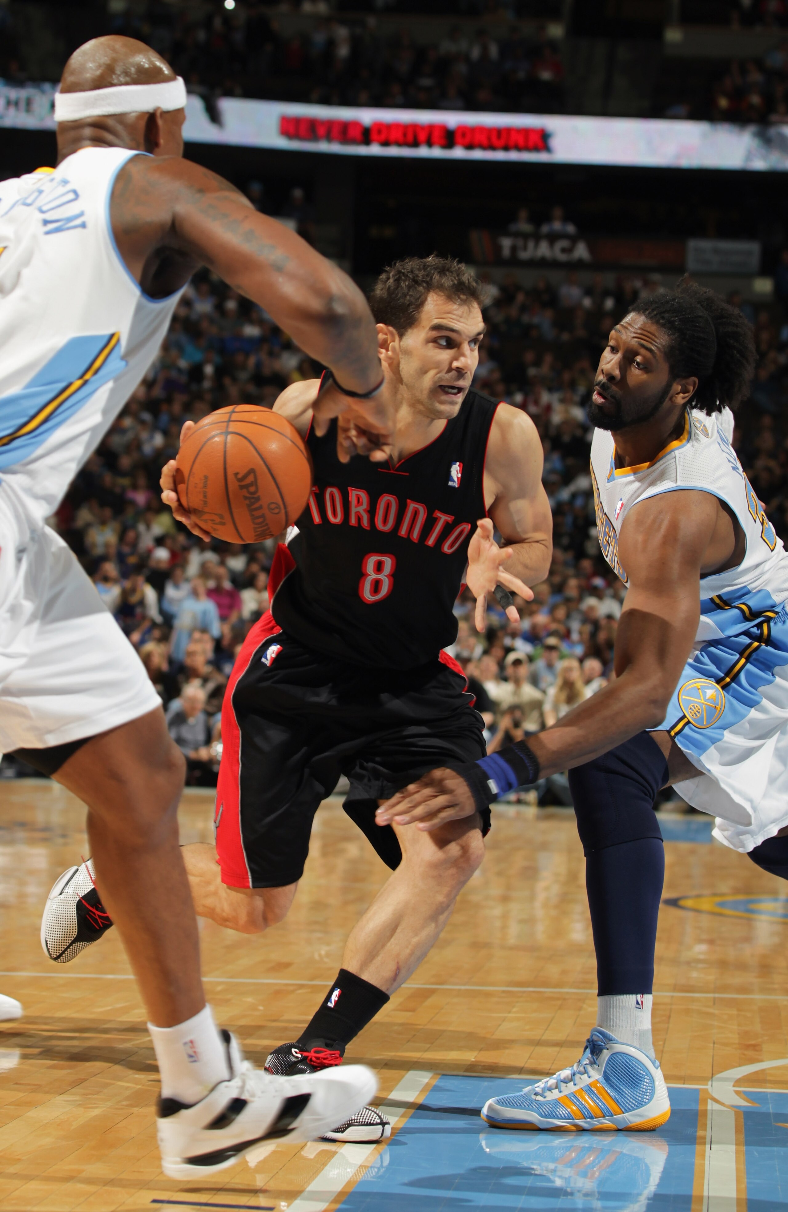 DENVER, CO - MARCH 21: Jose Calderon #8 of the Toronto Raptors drives to the basket between Al Harrington #7 and Nene #31 of the Denver Nuggets at the Pepsi Center on March 21, 2011 in Denver, Colorado. The Nuggets defeated the Raptors 123-90. NOTE TO US DENVER, CO - MARCH 21: Jose Calderon #8 of the Toronto Raptors drives to the basket between Al Harrington #7 and Nene #31 of the Denver Nuggets at the Pepsi Center on March 21, 2011 in Denver, Colorado. The Nuggets defeated the Raptors 123-90. NOTE TO US