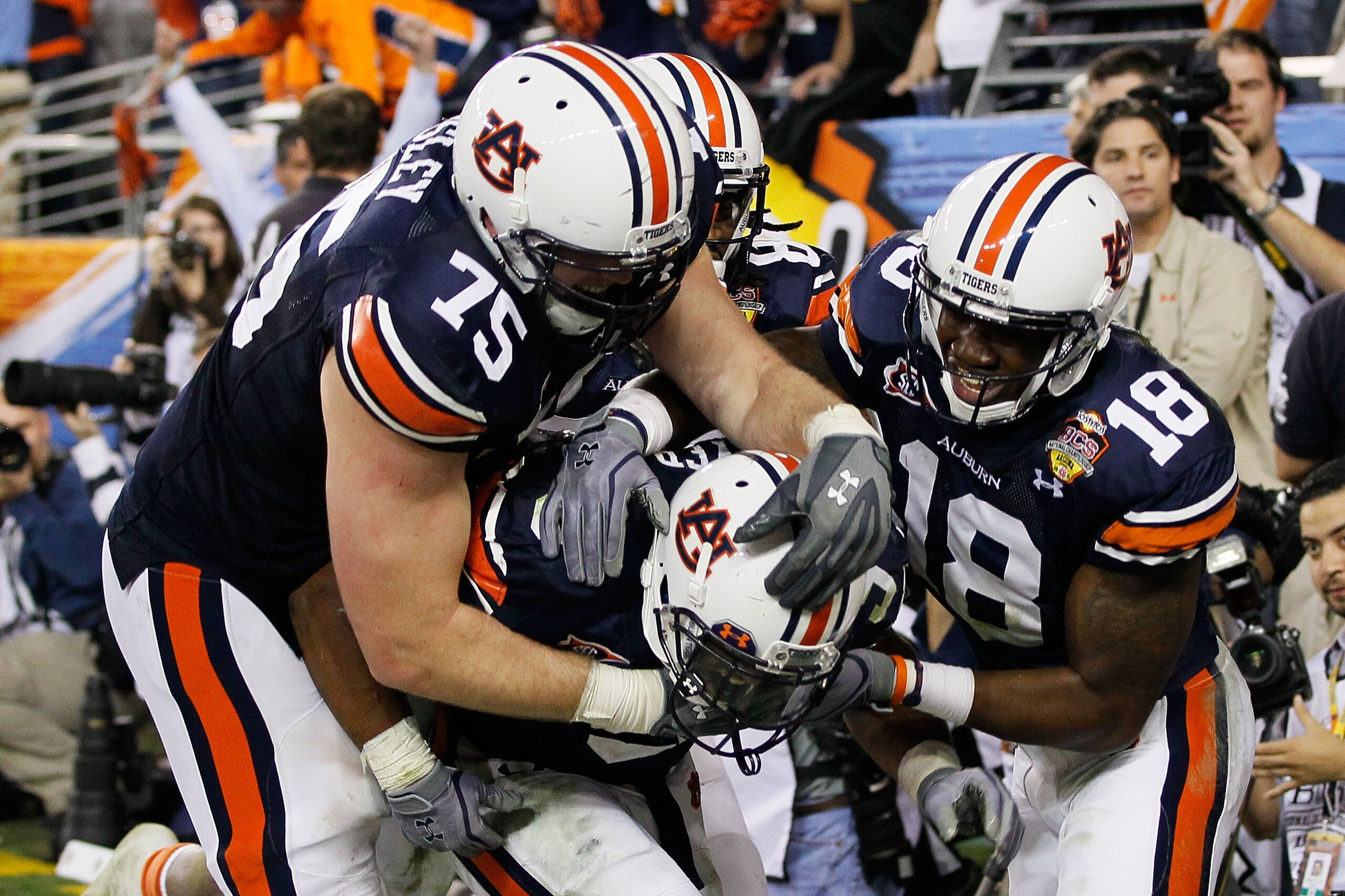 GLENDALE, AZ - JANUARY 10: (C) Michael Dyer #5 of the Auburn Tigers celebrates with teammates Brandon Mosley #75 and Kodi Burns #18 after he ran the ball for 16-yards and is called down at the one-yardline with 10 seconds remaining in the fourth quarter GLENDALE, AZ - JANUARY 10: (C) Michael Dyer #5 of the Auburn Tigers celebrates with teammates Brandon Mosley #75 and Kodi Burns #18 after he ran the ball for 16-yards and is called down at the one-yardline with 10 seconds remaining in the fourth quarter
