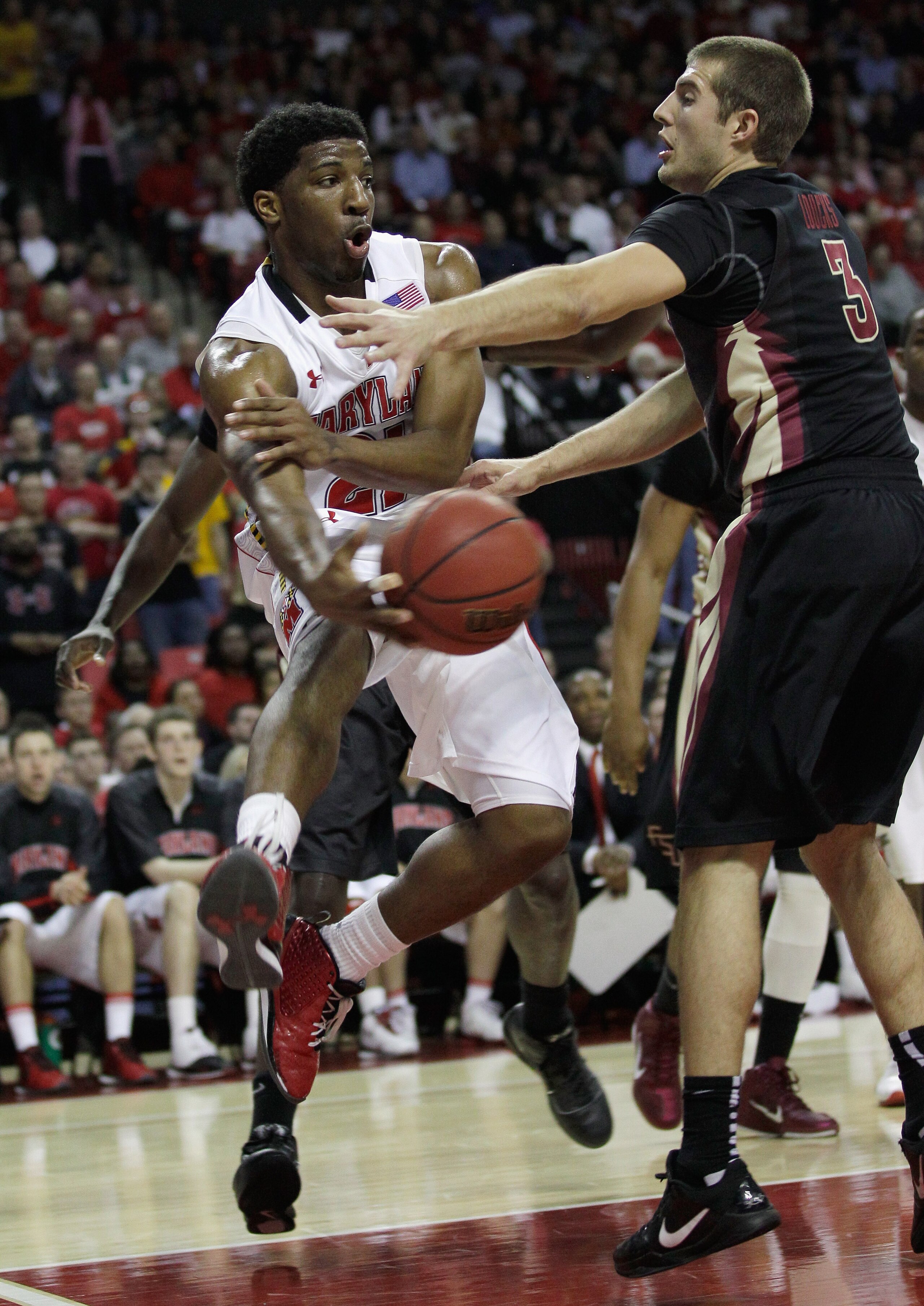 COLLEGE PARK, MD - FEBRUARY 23: Pe'Shon Howard, left, of the Maryland Terrapins passes around Luke Loucks #3 of the  Florida State Seminoles at the Comast Center on February 23, 2011 in College Park, Maryland.  (Photo by Rob Carr/Getty Images)