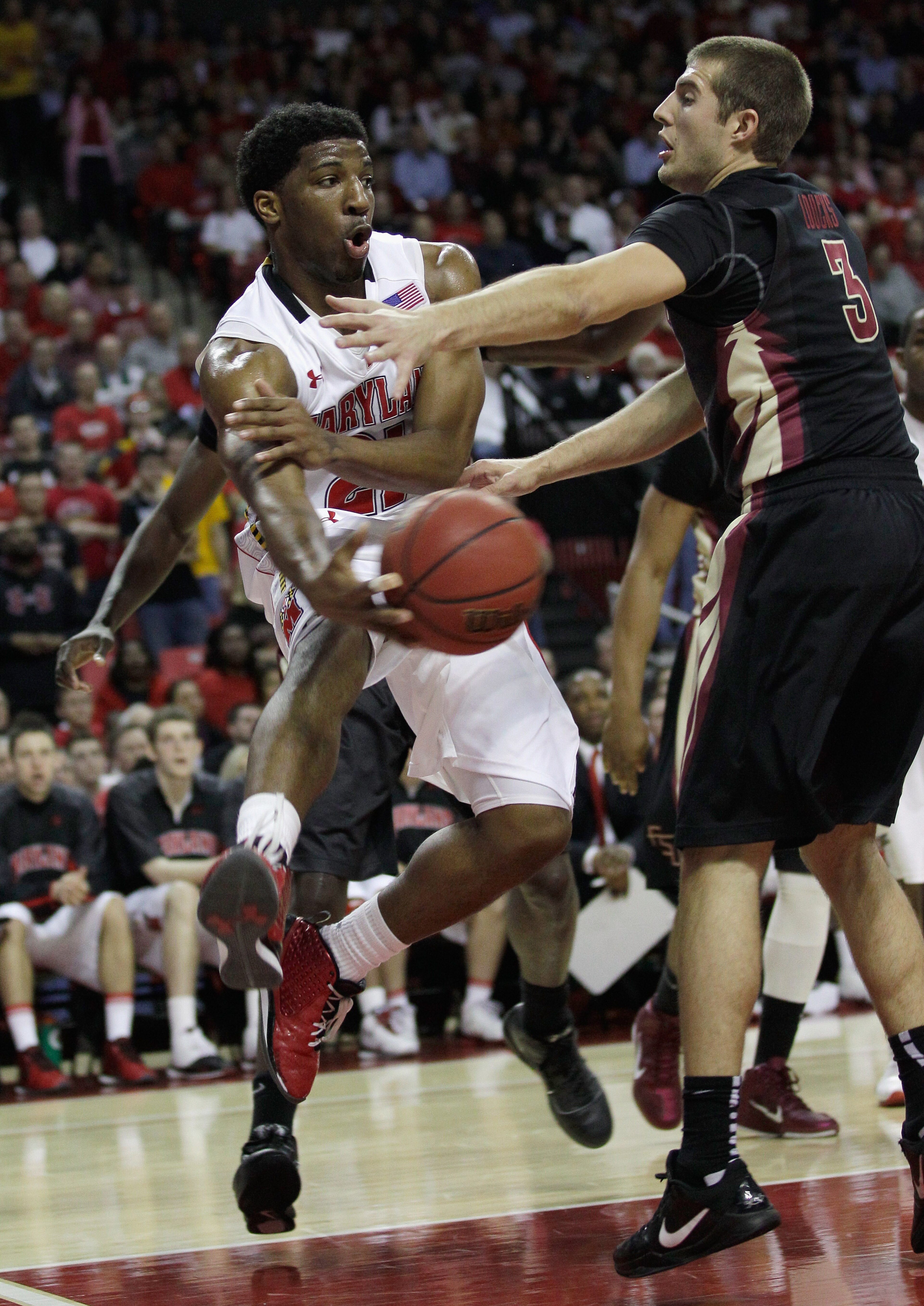 COLLEGE PARK, MD - FEBRUARY 23: Pe'Shon Howard, left, of the Maryland Terrapins passes around Luke Loucks #3 of the  Florida State Seminoles at the Comast Center on February 23, 2011 in College Park, Maryland.  (Photo by Rob Carr/Getty Images)