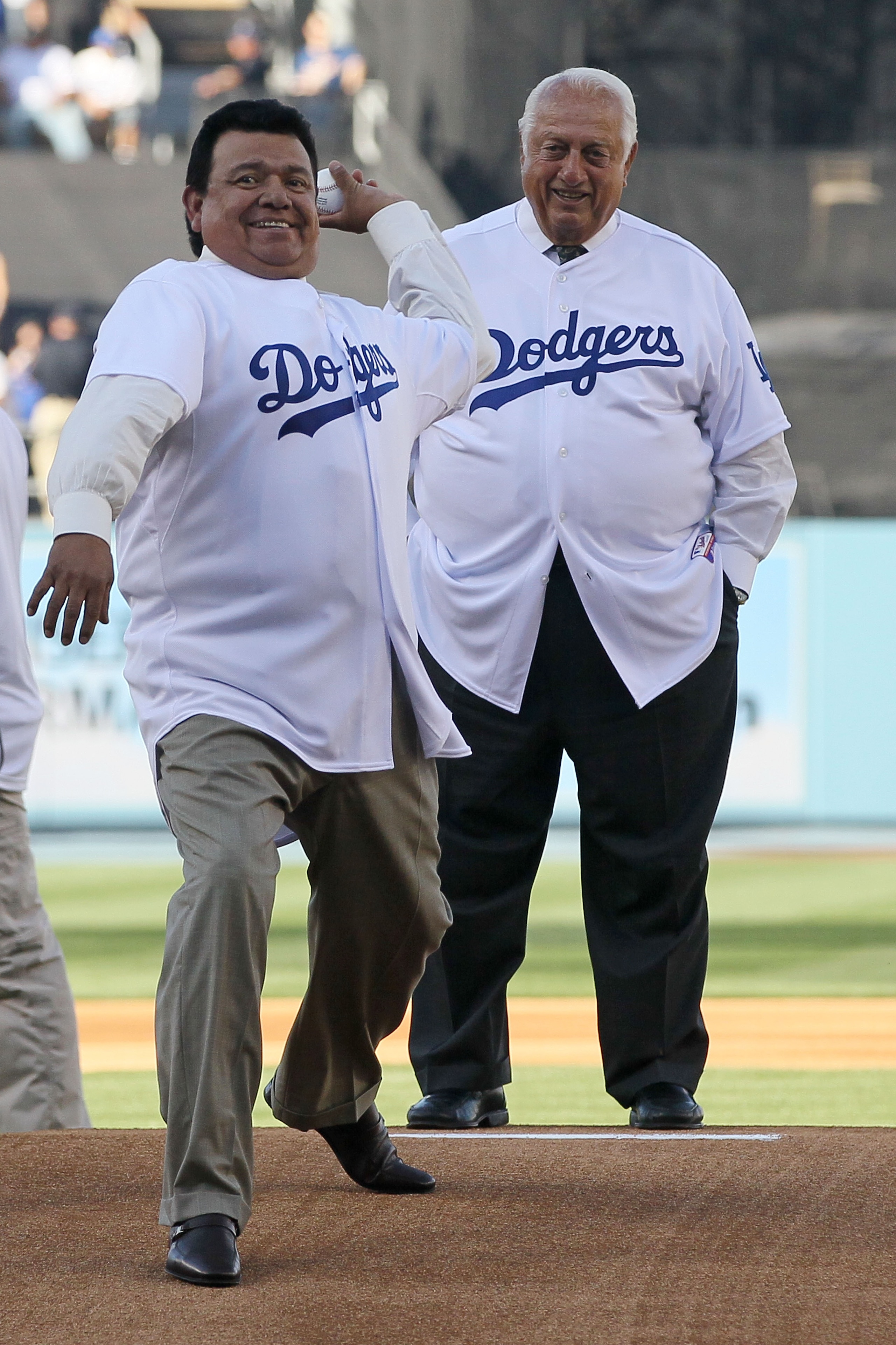 LOS ANGELES, CA - MARCH 31:  Former Los Angeles Dodgers pitcher Fernando Valenzuela throws out the ceremonial first pitch as former Dodger manager Tommy Lasorda looks on prior to the Dodgers playing the San Francisco Giants on Opening Day at Dodger Stadiu