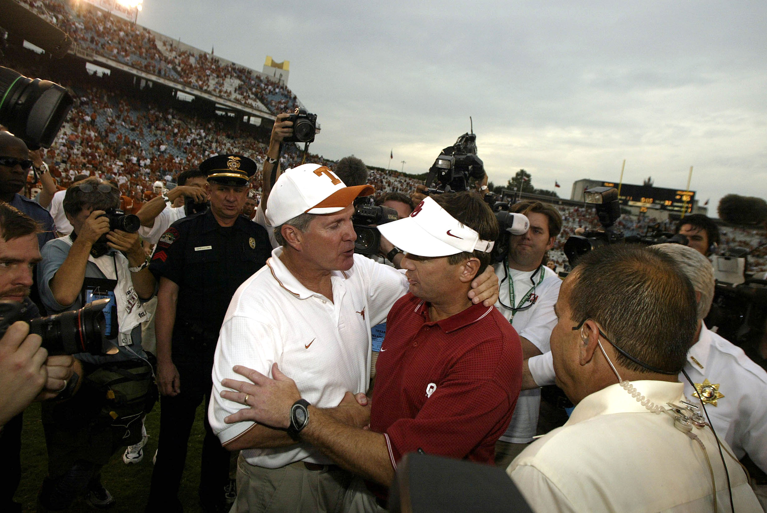DALLAS - OCTOBER 11:  Head coach Mack Brown of the Texas Longhorns and Bob Stoops of the Oklahoma Sooners greet each other at the end of the game at the Cotton Bowl on October 11, 2003 in Dallas, Texas.  The Sooners defeated the Longhorns 65-13.  (Photo b