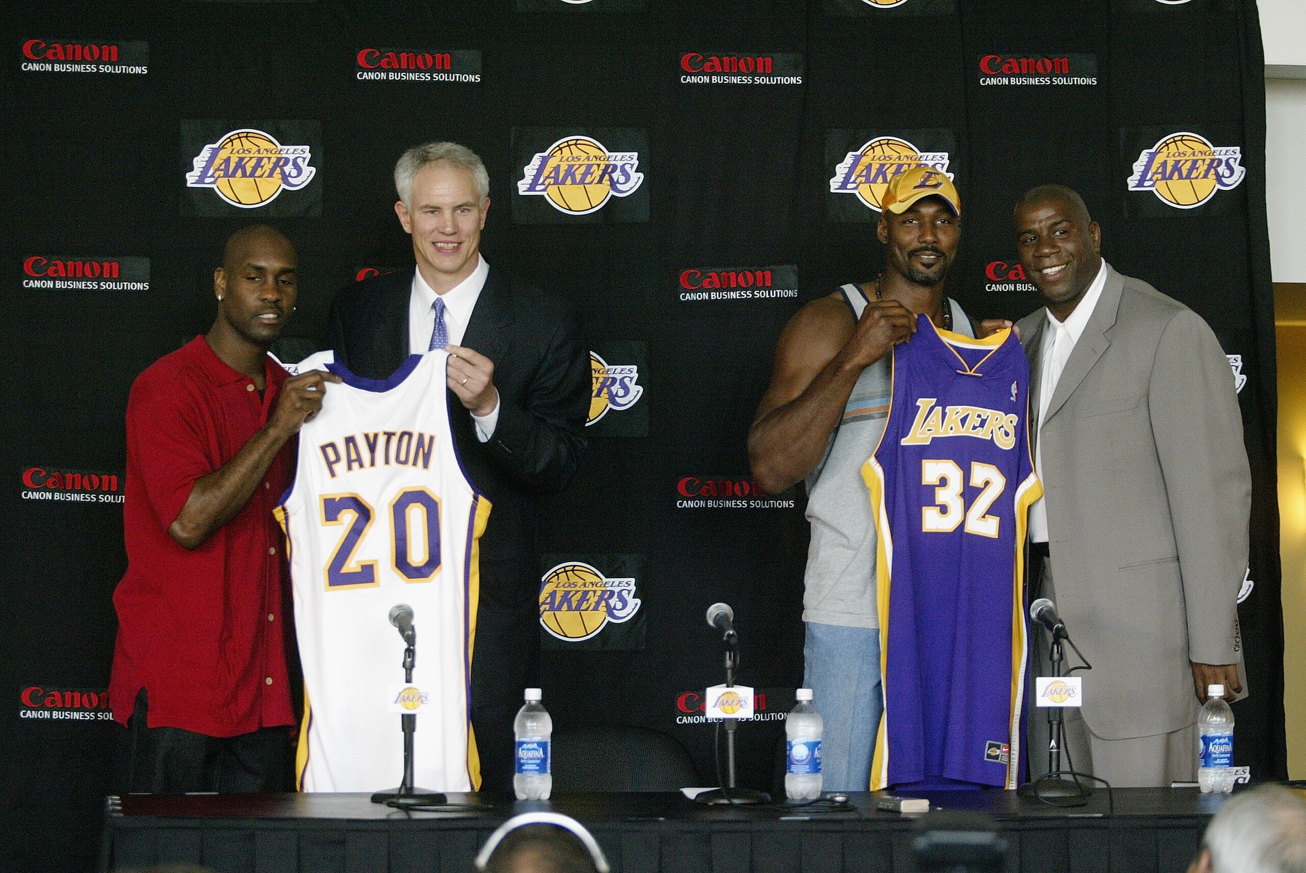 LOS ANGELES - JULY 17:  (L to R) Gary Payton, general manager Mitch Kupchak, Karl Malone and Magic Johnson display new jerseys during a press conference discussing the signings of Gary Payton and Karl Malone by the Los Angeles Lakers at Staples Center on