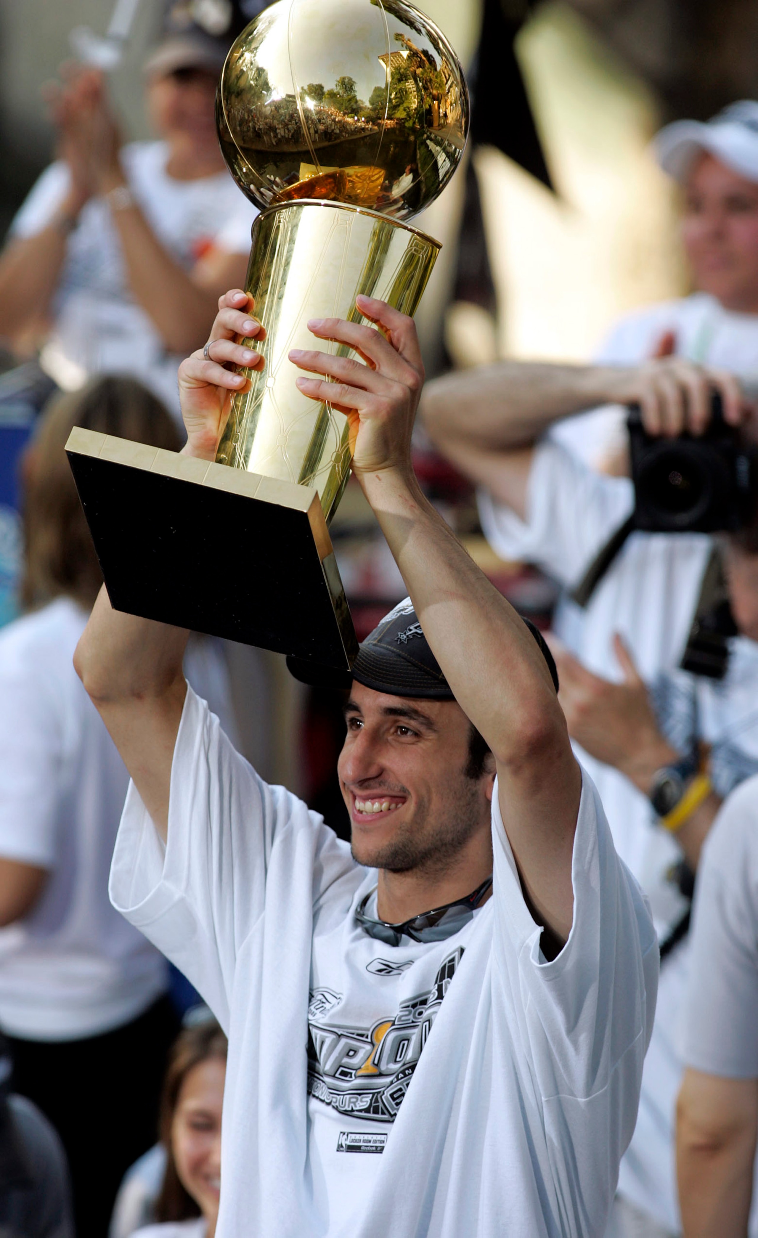 SAN ANTONIO - JUNE 25: San Antonio Spur Manu Ginobili holds the NBA Championship Trophy for the fans to see during the Spurs Championship Celebration along the San Antonio River Walk June 25, 2005 in San Antonio, Texas. NOTE TO USER:  User expressly ackno
