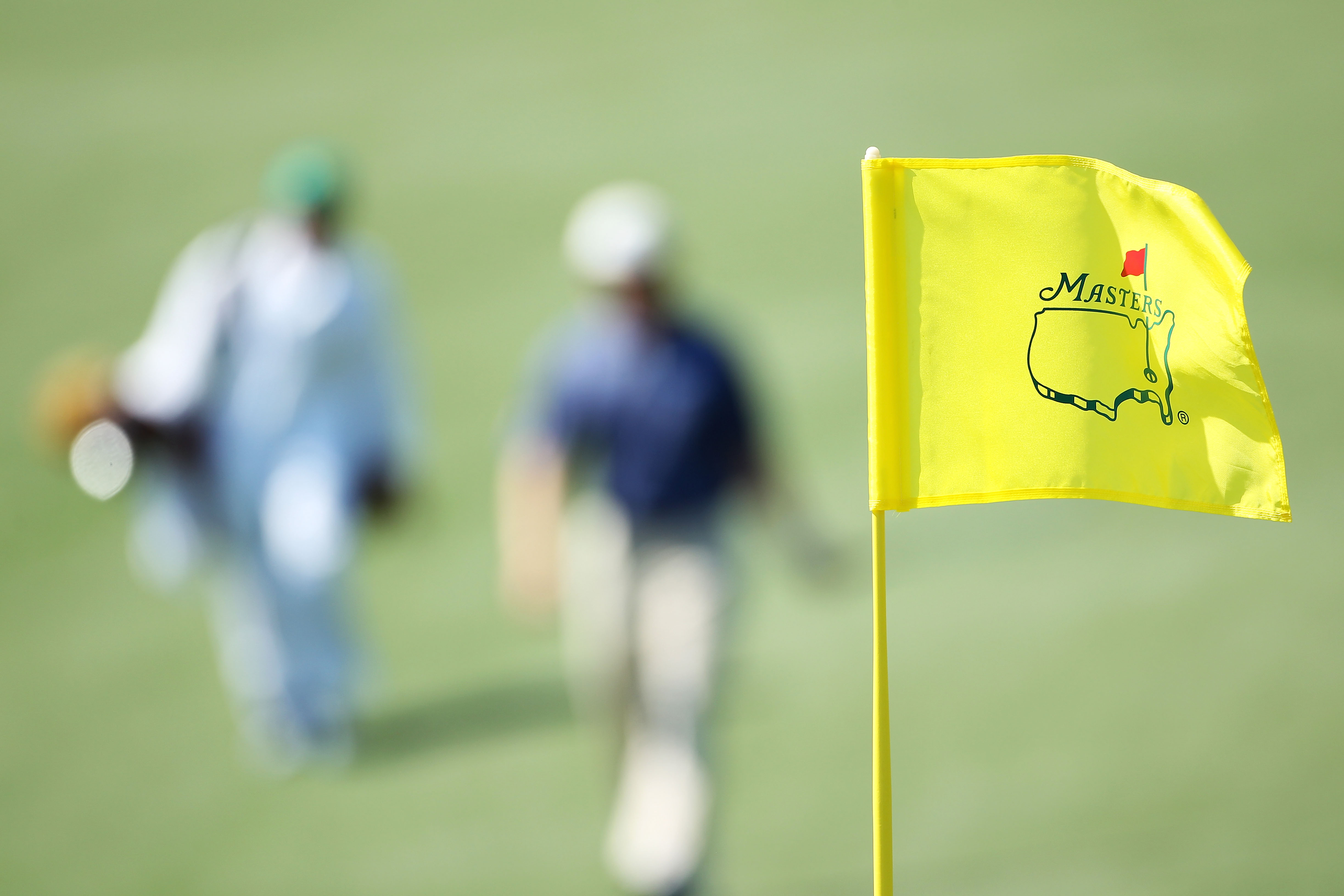 AUGUSTA, GA - APRIL 04:  A Masters flagstick is seen as a player and caddie approach a green during a practice round prior to the 2011 Masters Tournament at Augusta National Golf Club on April 4, 2011 in Augusta, Georgia.  (Photo by Andrew Redington/Getty