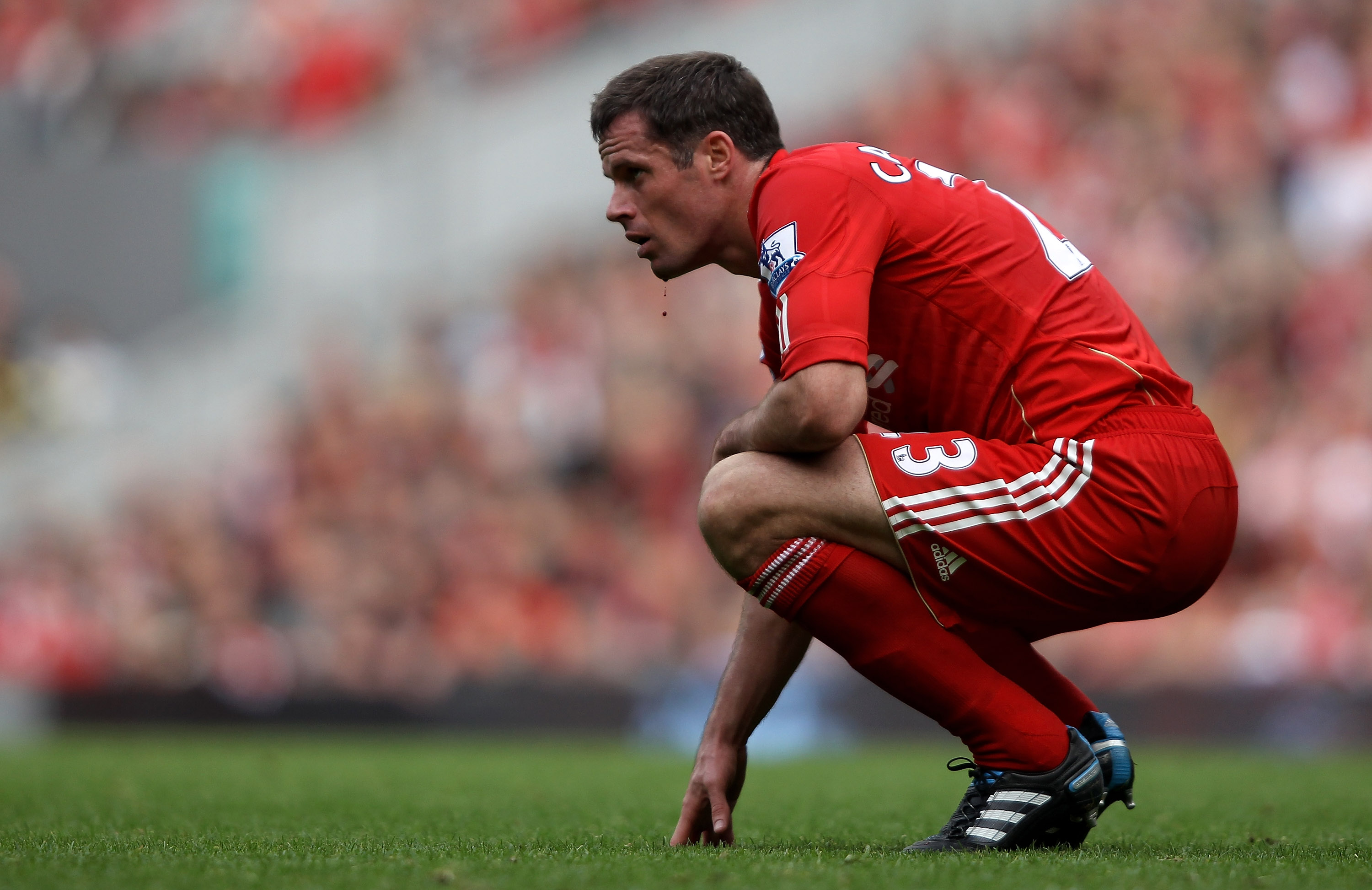 LIVERPOOL, ENGLAND - SEPTEMBER 25:  Jamie Carragher of Liverpool waits for treatment as blood drips off him after a clash of heads with team mate Martin Skrtel during the Barclays Premier League match between Liverpool and Sunderland at at Anfield on Sept