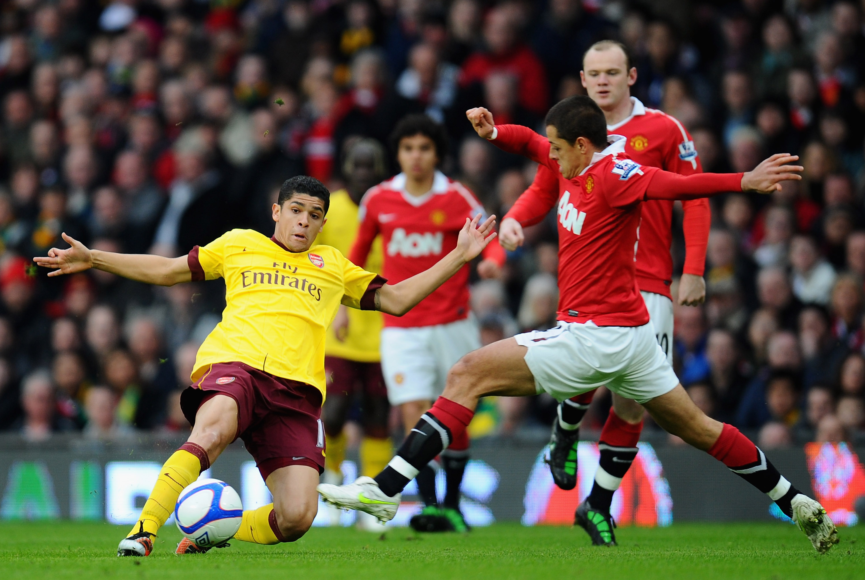 MANCHESTER, ENGLAND - MARCH 12:  Denilson of Arsenal and Javier Hernandez of Manchester United challenge for the ball during the FA Cup sponsored by E.On Sixth Round match between Manchester United and Arsenal at Old Trafford on March 12, 2011 in Manchest