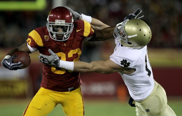 LOS ANGELES - NOVEMBER 27:  Wide receiver Ronald Johnson #83 of the USC Trojans carries ball against safety Zeke Motta #17 of the Notre Dame Fighting Irish at the Los Angeles Memorial Coliseum on November 27, 2010 in Los Angeles, California.   (Photo by S