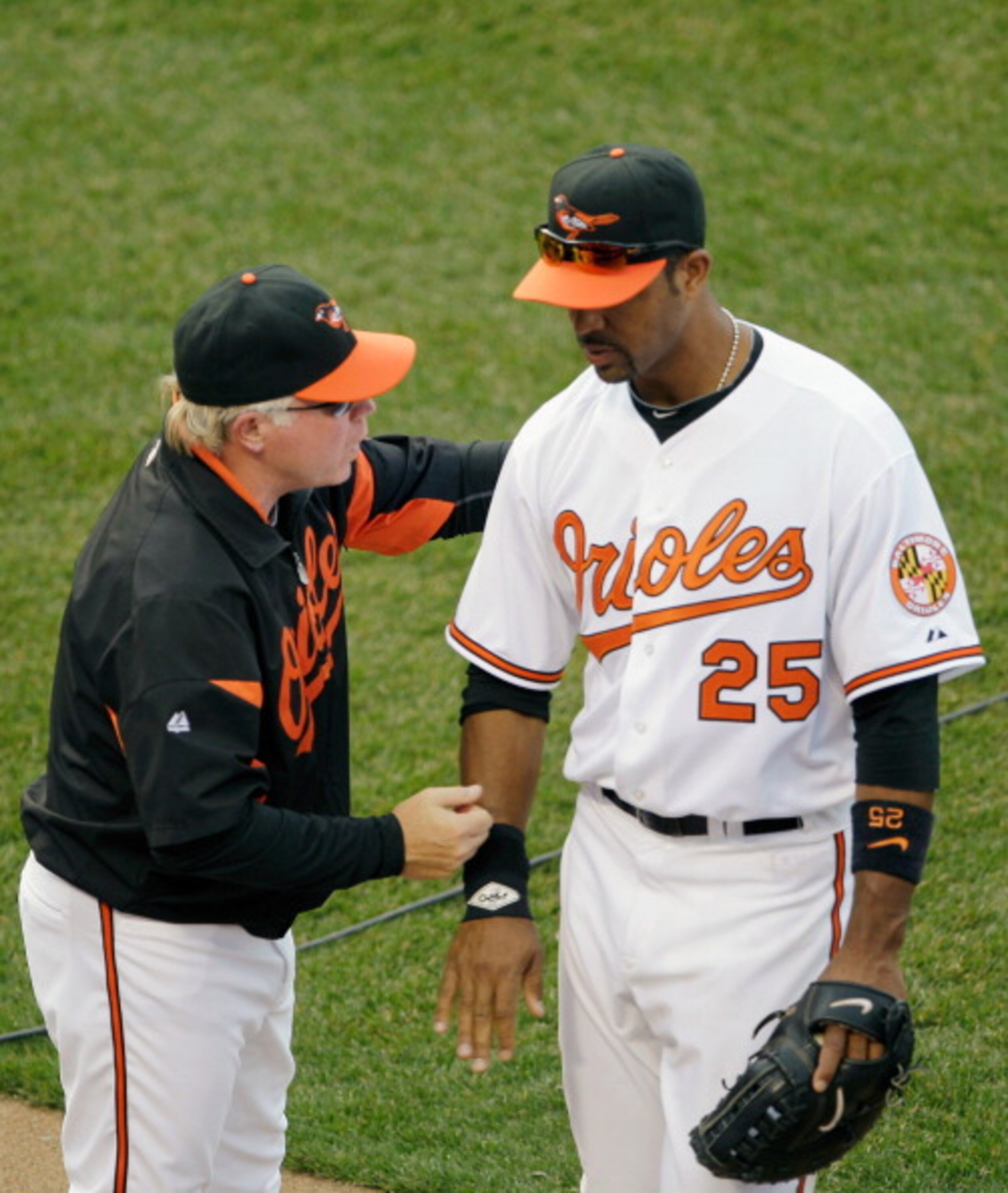 BALTIMORE, MD - APRIL 04: Manager Buck Showalter #26 of the Baltimore Orioles congratulates first baseman Derrek Lee #25 of the Baltimore Orioles after they defeated the Detroit Tigers during opening day at Oriole Park at Camden Yards on April 4, 2011 in