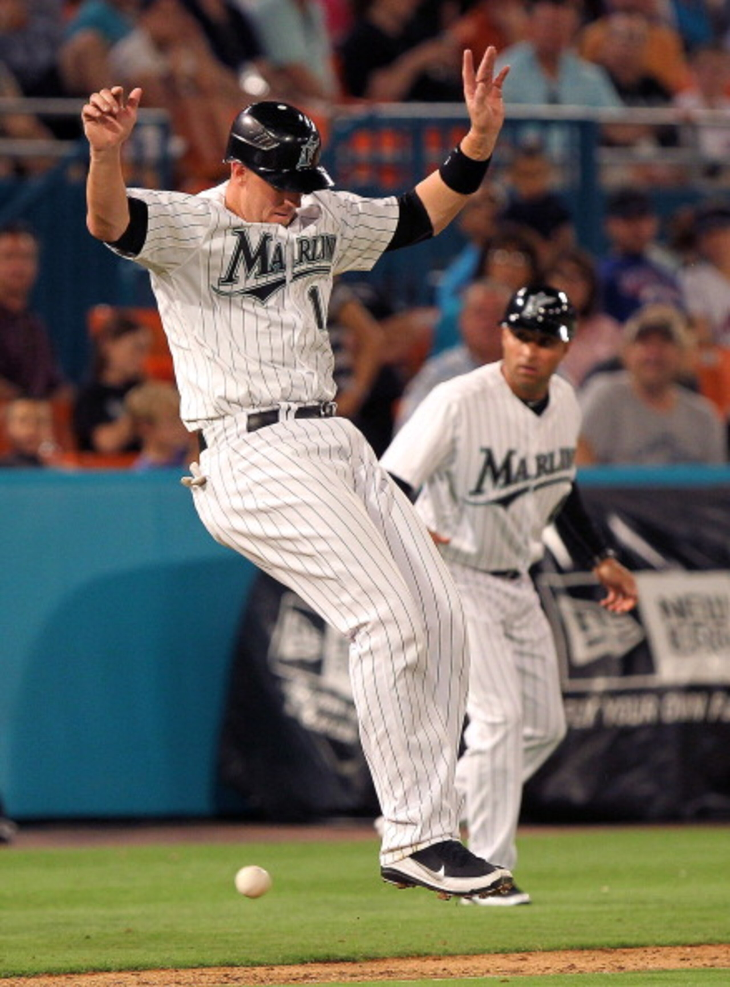 MIAMI GARDENS, FL - APRIL 01:  John Buck #14 of the Florida Marlins jumps over a foul ball during opening day against the New York Mets at Sun Life Stadium on April 1, 2011 in Miami Gardens, Florida.  (Photo by Mike Ehrmann/Getty Images)