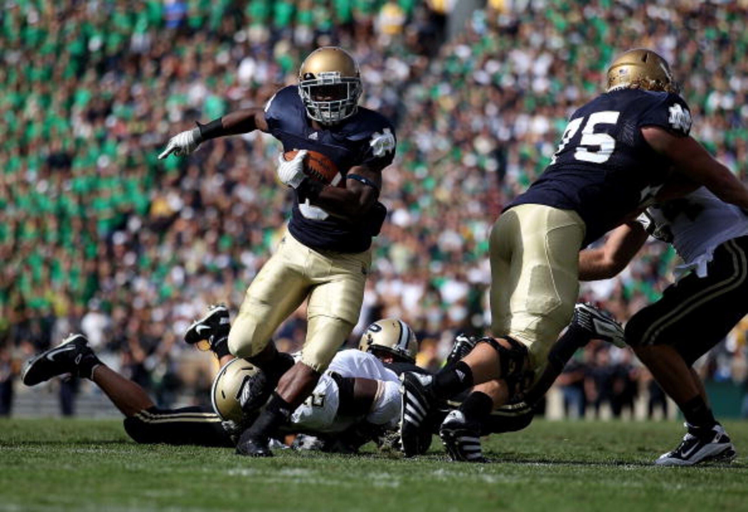 SOUTH BEND, IN - SEPTEMBER 04:  Armando Allen Jr. #5 of the Notre Dame Fighting Irish runs for a yardage as teammate Taylor Dever #75 blocks against the Purdue Boilermakers at Notre Dame Stadium on September 4, 2010 in South Bend, Indiana. Notre Dame defe