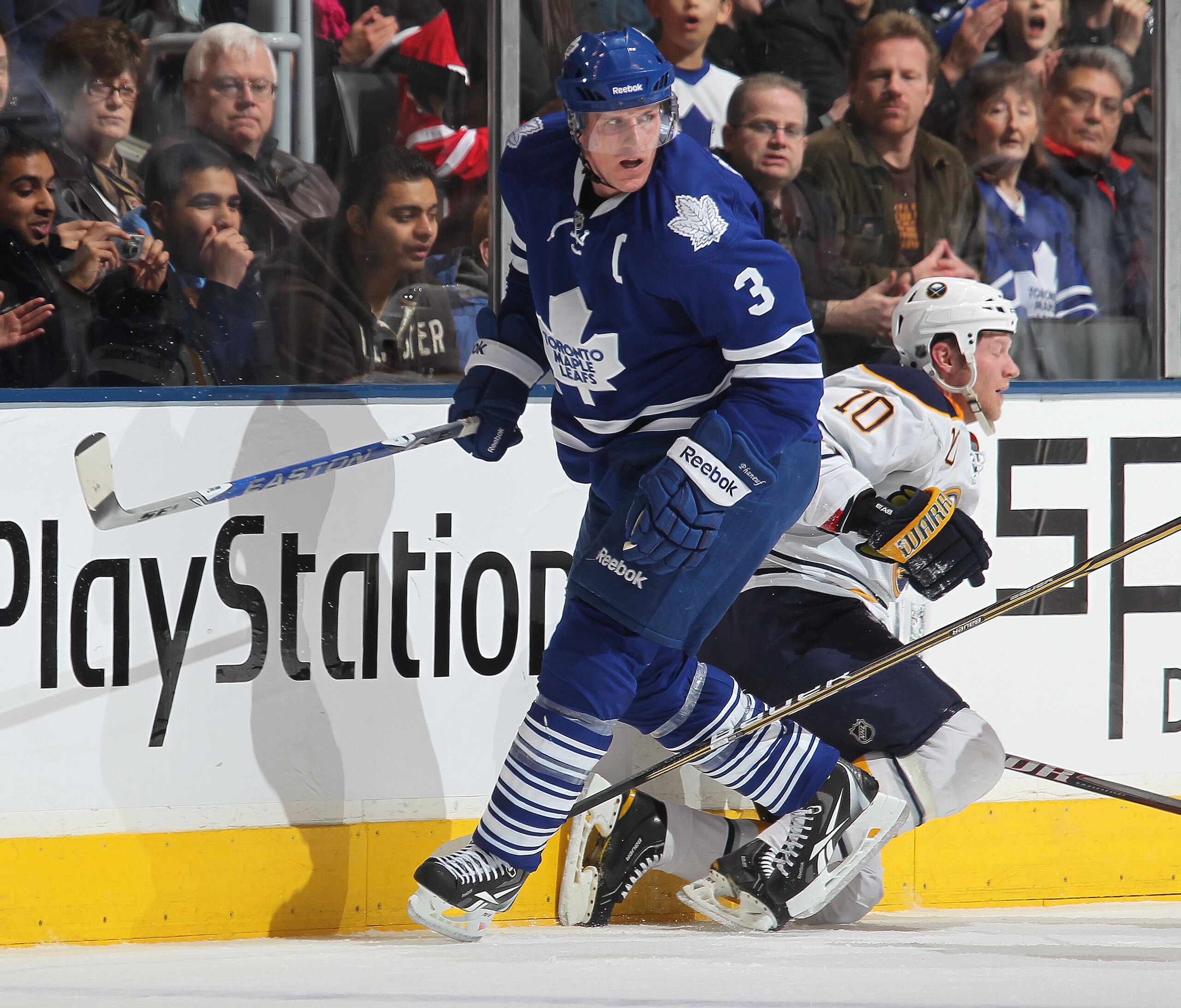 TORONTO, CANADA - MARCH 12:  Mark Parrish #10 of the Buffalo Sabres takes a big hit from Dion Phaneuf #3 of the Toronto Maple Leafs in a game on March 12, 2011 at the Air Canada Centre in Toronto, Canada. The Leafs defeated the Sabres 4-3. (Photo by Claus