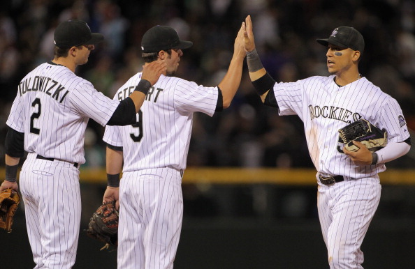 DENVER, CO - APRIL 05:  Troy Tulowitzki #2, Ian Stewart #9 and Carlos Gonzalez #5 of the Colorado Rockies celebrate their victory over the Los Angeles Dodgers at Coors Field on April 5, 2011 in Denver, Colorado. The Rockies defeated the Dodgers 3-0.  (Pho