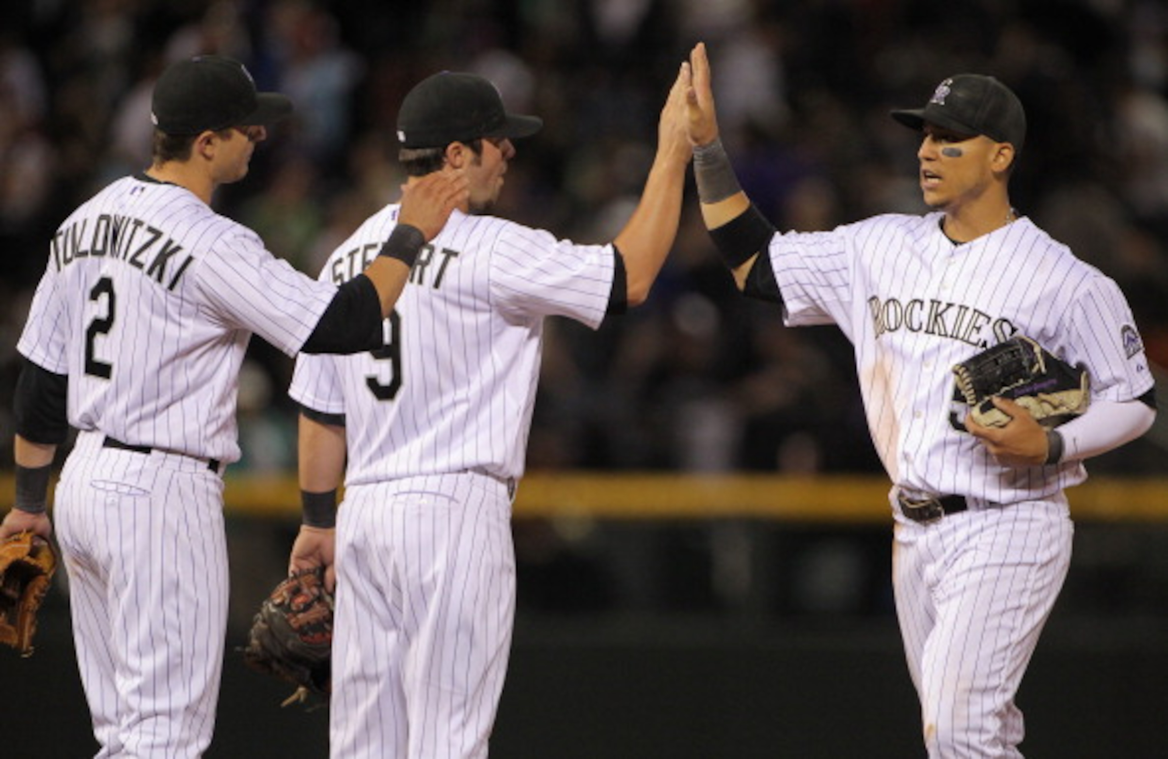 DENVER, CO - APRIL 05: Troy Tulowitzki #2, Ian Stewart #9 and Carlos Gonzalez #5 of the Colorado Rockies celebrate their victory over the Los Angeles Dodgers at Coors Field on April 5, 2011 in Denver, Colorado. The Rockies defeated the Dodgers 3-0. (Pho DENVER, CO - APRIL 05: Troy Tulowitzki #2, Ian Stewart #9 and Carlos Gonzalez #5 of the Colorado Rockies celebrate their victory over the Los Angeles Dodgers at Coors Field on April 5, 2011 in Denver, Colorado. The Rockies defeated the Dodgers 3-0. (Pho