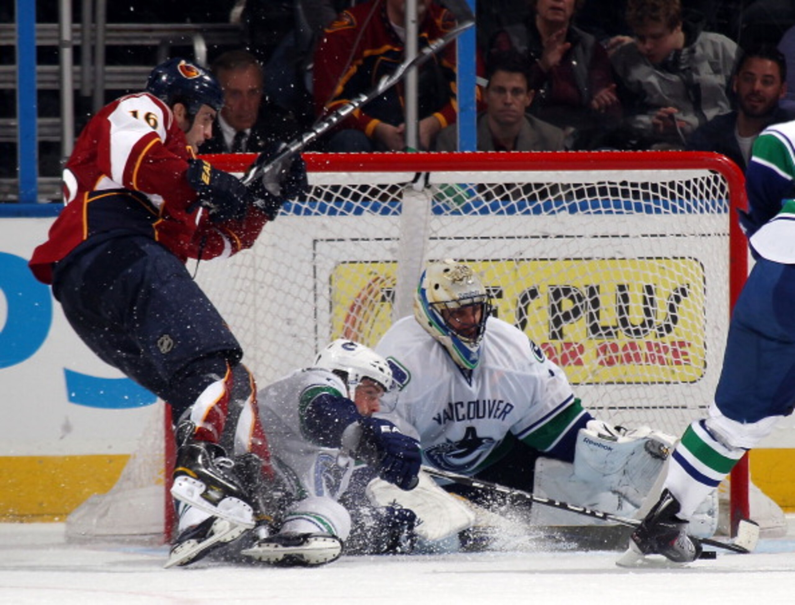 ATLANTA, GA - MARCH 25: Roberto Luongo #1 of the Vancouver Canucks makes the kick save in the third period as Andrew Ladd #16 of the Atlanta Thrashers is tripped up in front at the Philips Arena on March 25, 2011 in Atlanta, Georgia. The Canucks defeated