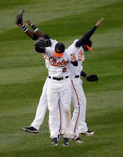 BALTIMORE, MD - APRIL 04:  Felix Pie #18 of the Baltimore Orioles (L) and teammates Nick Markakis #21 (C) and Adam Jones #10 celebrate in the outfield after the Orioles defeated the Detroit Tigers 5-1 during opening day at Oriole Park at Camden Yards on A