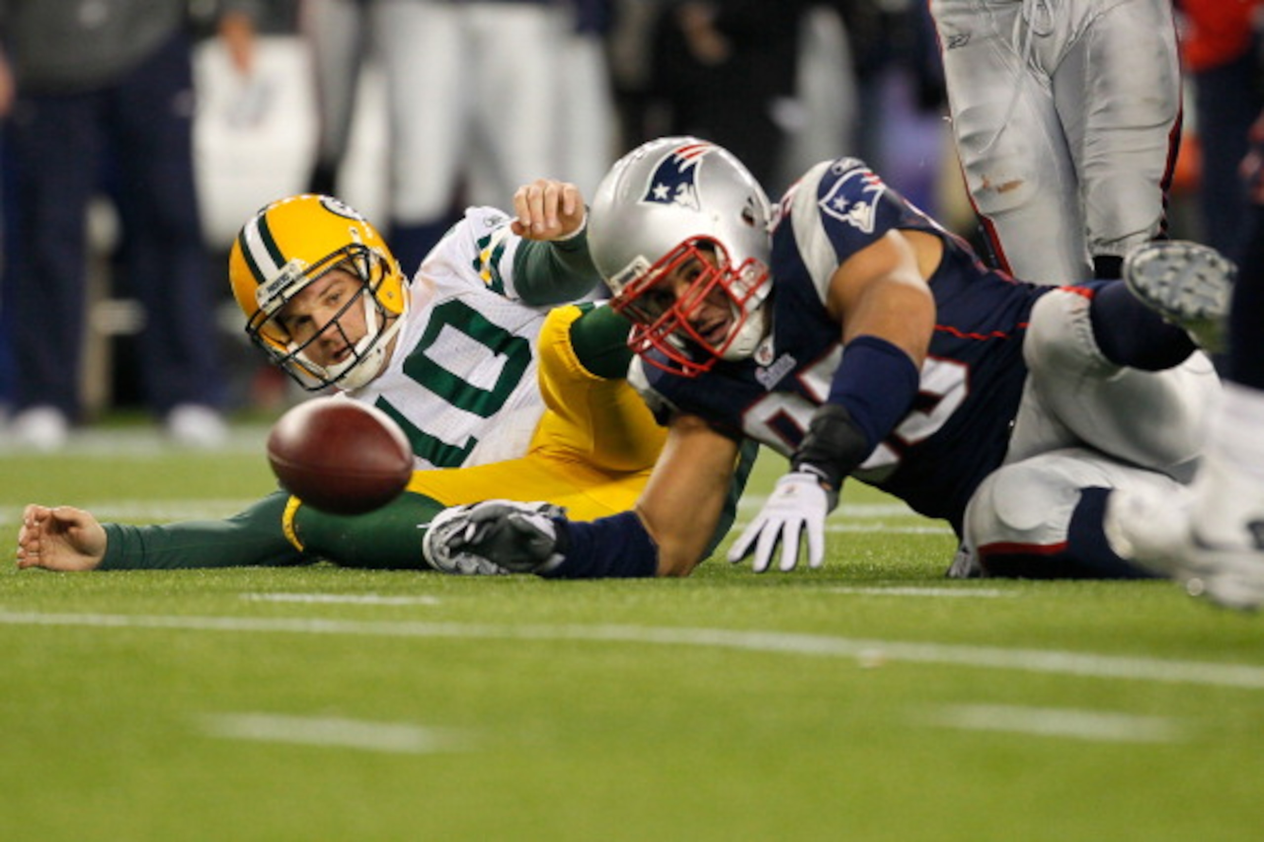 FOXBORO, MA - DECEMBER 19:  Quarterback Matt Flynn #10 of the Green Bay Packers fights for possession of a loose ball after being sacked by linebacker Tully Banta-Cain #95 of the New England Patriots during the fourth quarter of the game at Gillette Stadi