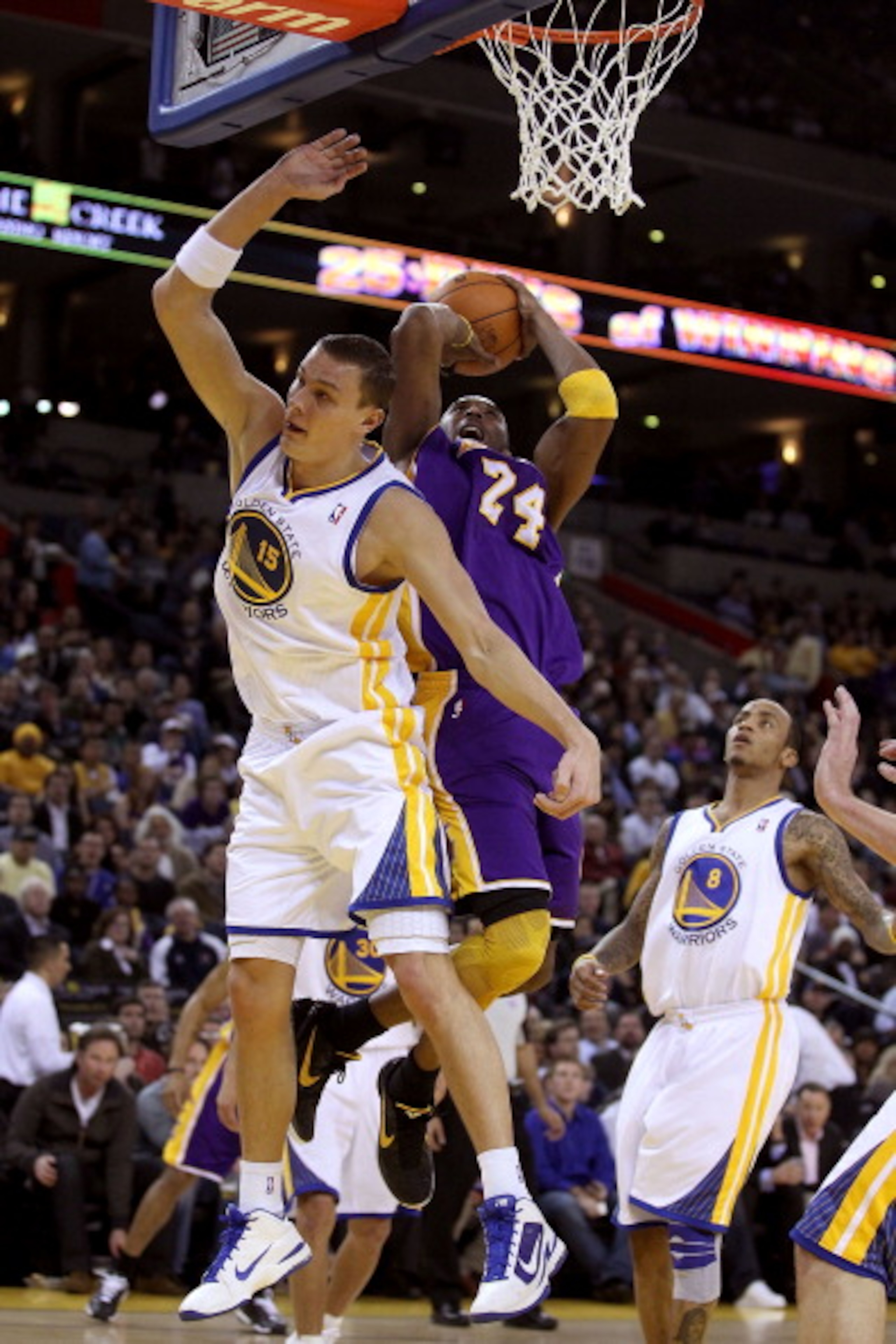 OAKLAND, CA - JANUARY 12: Kobe Bryant #24 of the Los Angeles Lakers is fouled by Andris Biedrins #15 of the Golden State Warriors at Oracle Arena on January 12, 2011 in Oakland, California. NOTE TO USER: User expressly acknowledges and agrees that, by dow