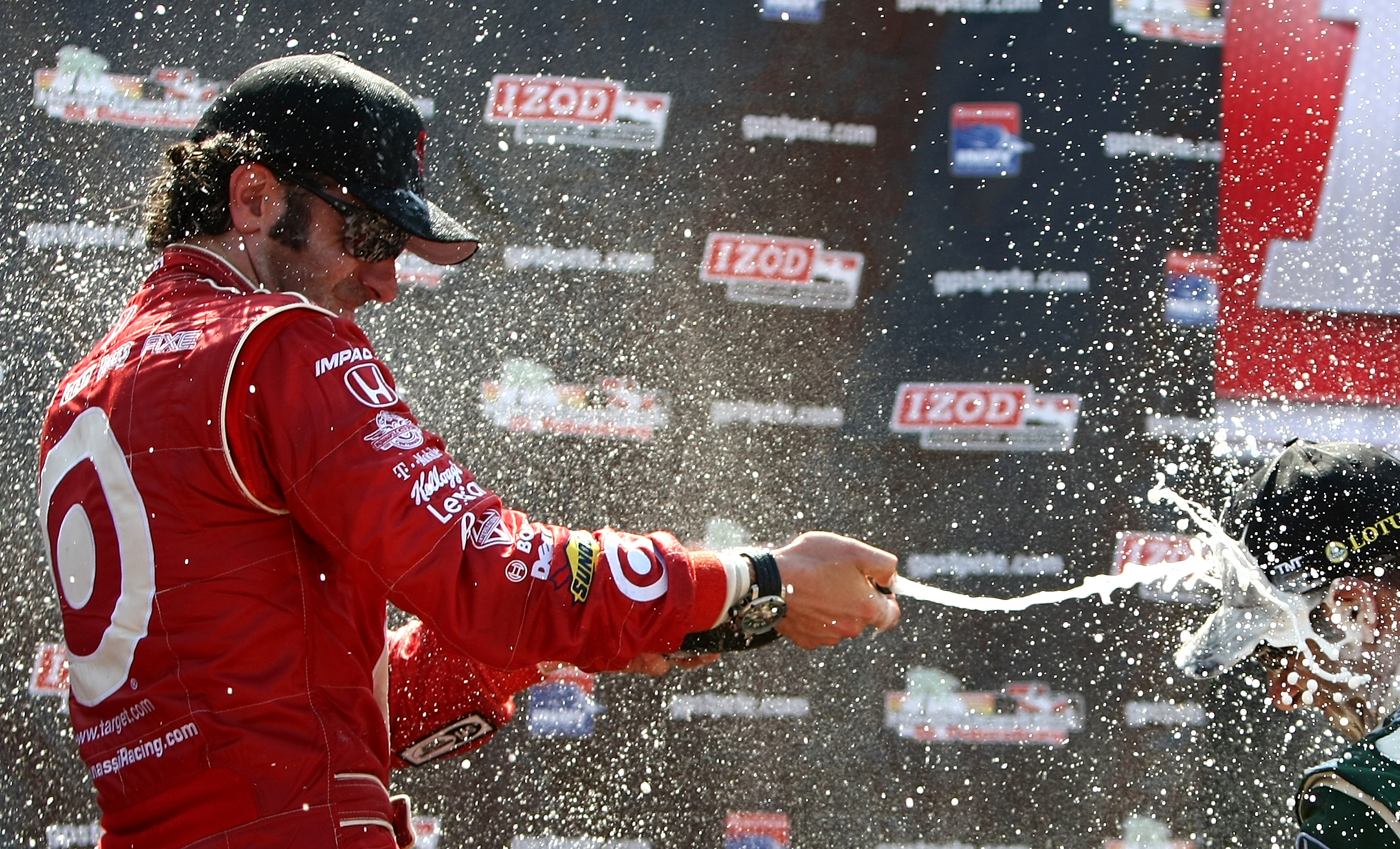 ST. PETERSBURG, FL - MARCH 27: Race winner, Dario Franchitti, driver of the #10 target Chip Ganassi Racing Dallara Honda sprays 3rd place driver Tony Kanaan with champagne during the IndyCar Series Honda Grand Prix of St. Petersburg on March 27, 2011 in