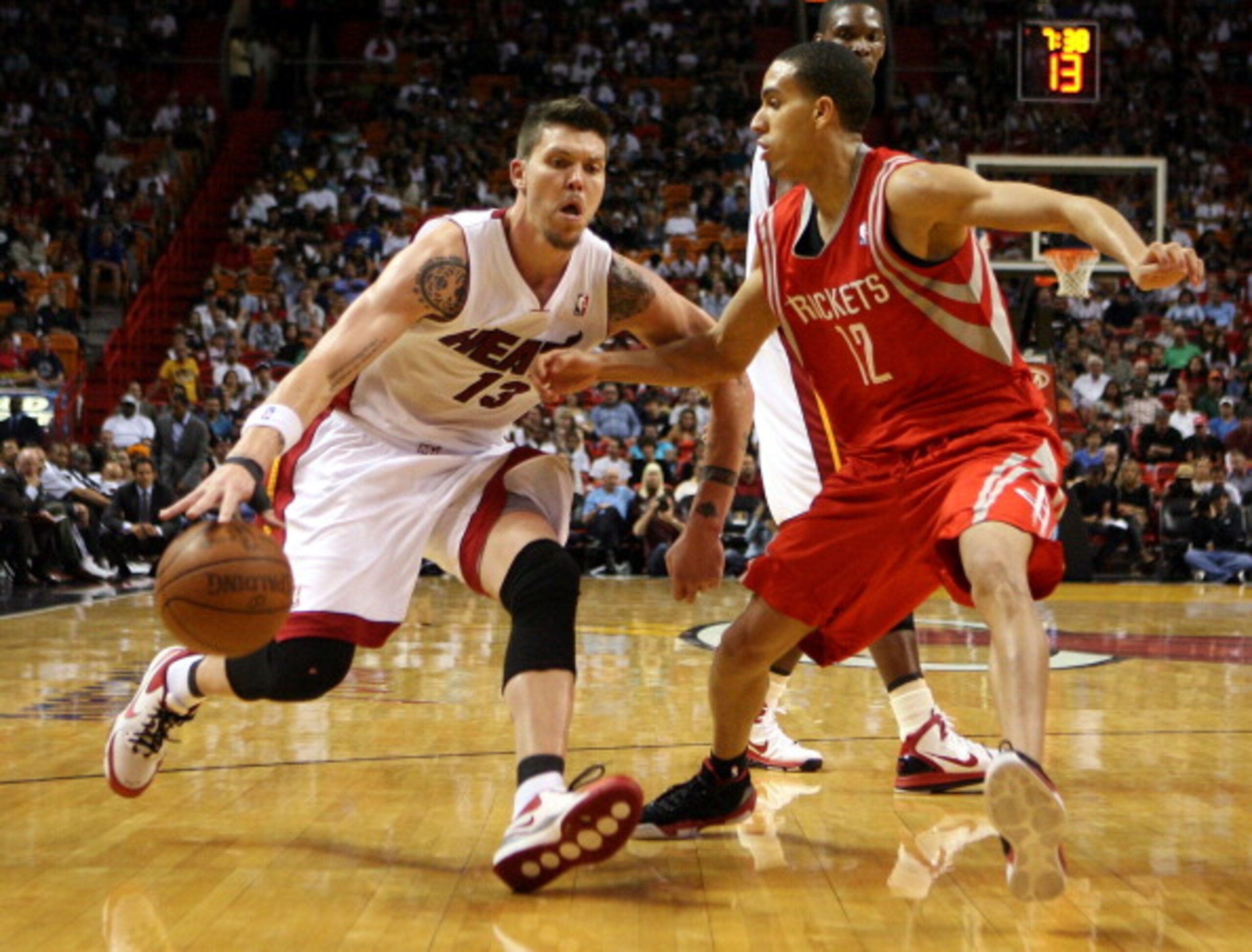 MIAMI, FL - MARCH 27:  Forward Mike Miller #13 of the Miami Heat drives against Forward Kevin Martin #12 of the Houston Rockets  at American Airlines Arena on March 27, 2011 in Miami, Florida. NOTE TO USER: User expressly acknowledges and agrees that, by
