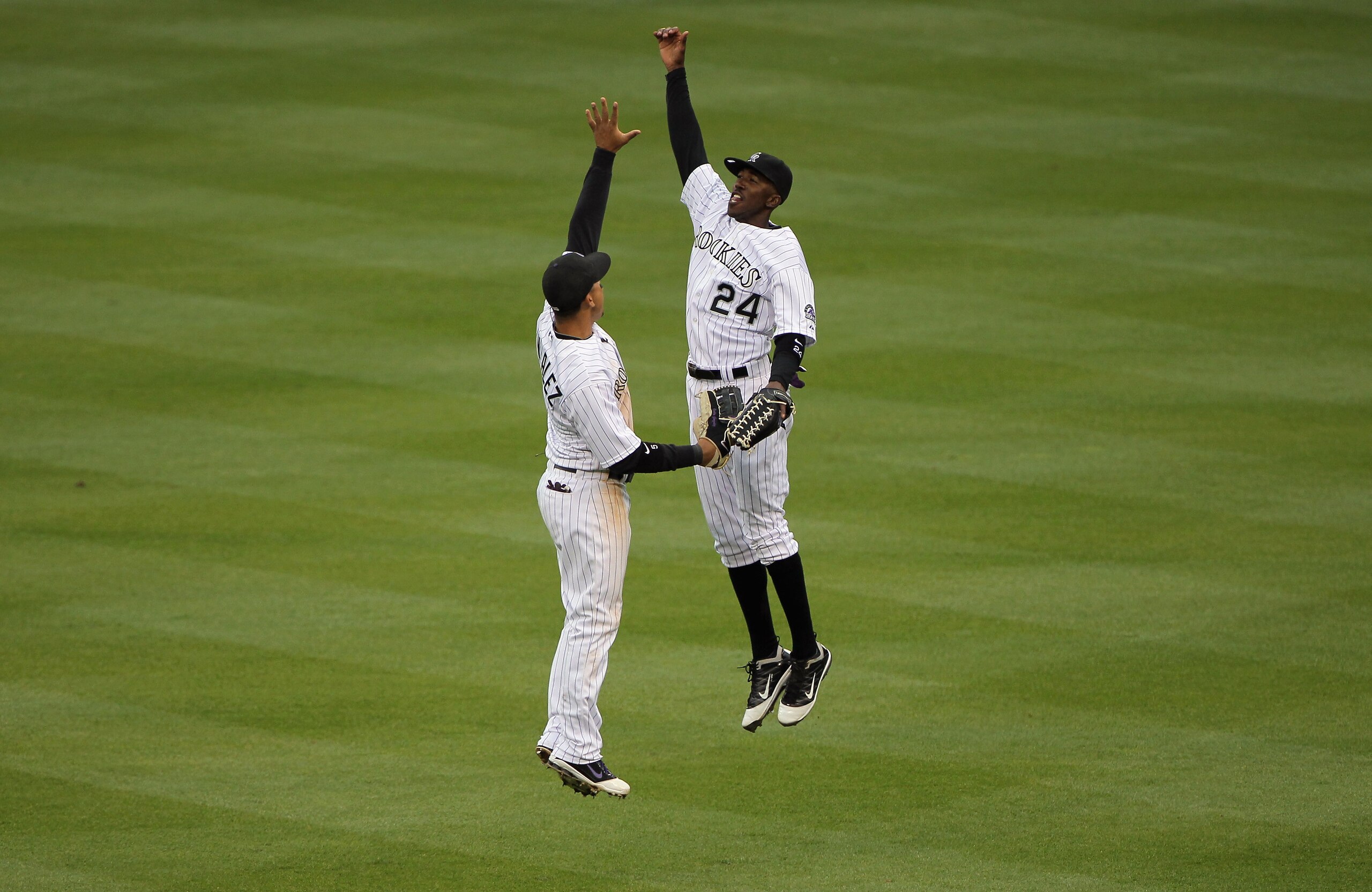 DENVER, CO - APRIL 06:  Carlos Gonzalez #5 of the Colorado Rockies and Dexter Fowler #24 of the Colorado Rockies celebrate their victory over the Los Angeles Dodgers at Coors Field on April 6, 2011 in Denver, Colorado. The Rockies defeated the Dodgers 7-5