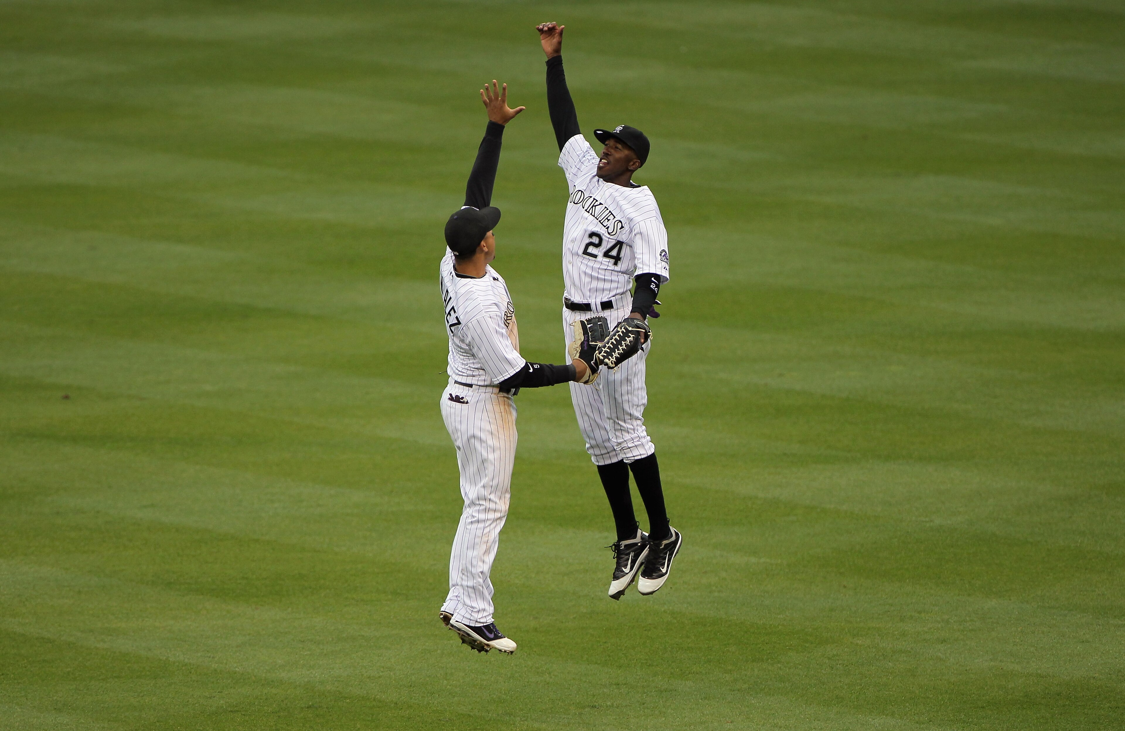 DENVER, CO - APRIL 06:  Carlos Gonzalez #5 of the Colorado Rockies and Dexter Fowler #24 of the Colorado Rockies celebrate their victory over the Los Angeles Dodgers at Coors Field on April 6, 2011 in Denver, Colorado. The Rockies defeated the Dodgers 7-5