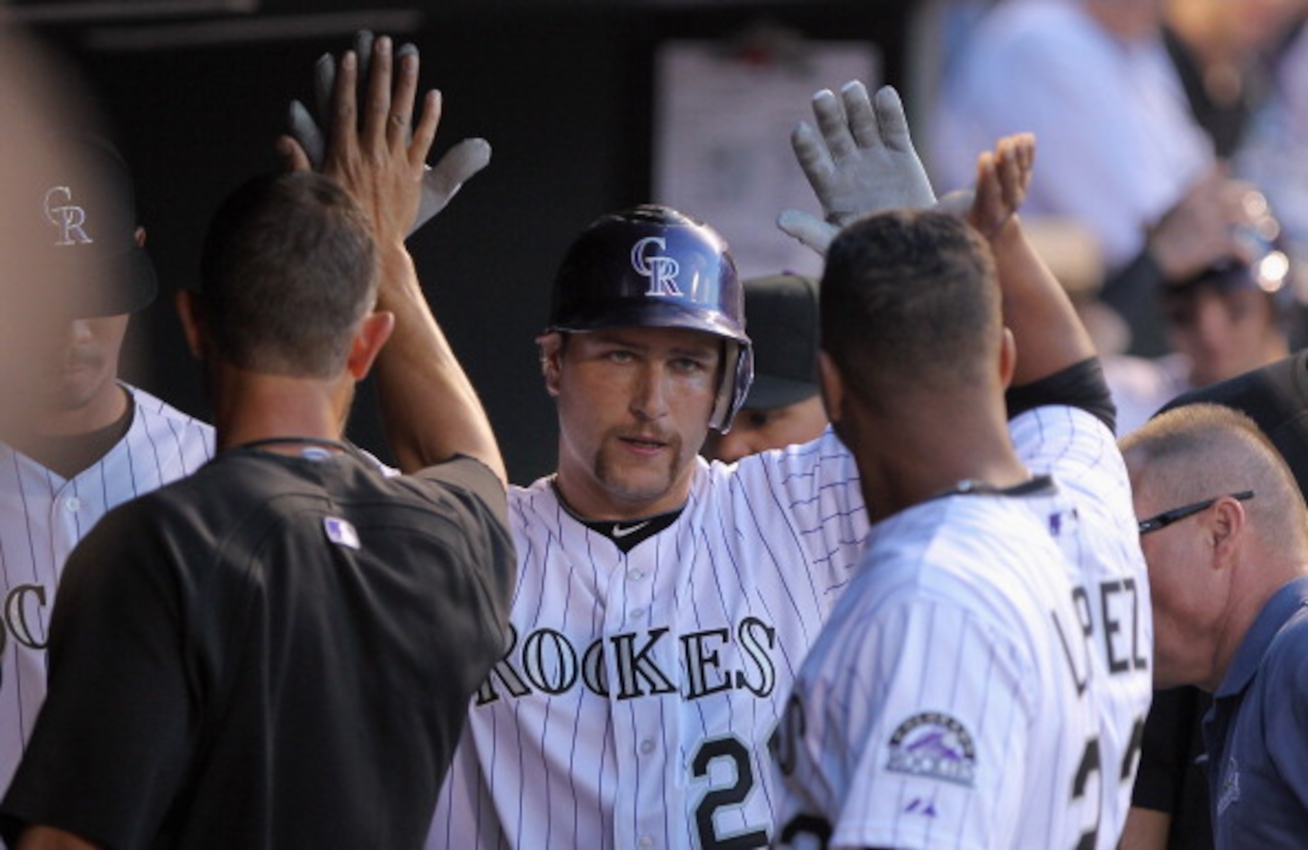 DENVER, CO - APRIL 02:  Catcher Chris Iannetta #20 of the Colorado Rockies is welcomed back to the dugout after scoring on a double by Dexter Fowler against the Arizona Diamondbacks in the third inning at Coors Field on April 2, 2011 in Denver, Colorado.