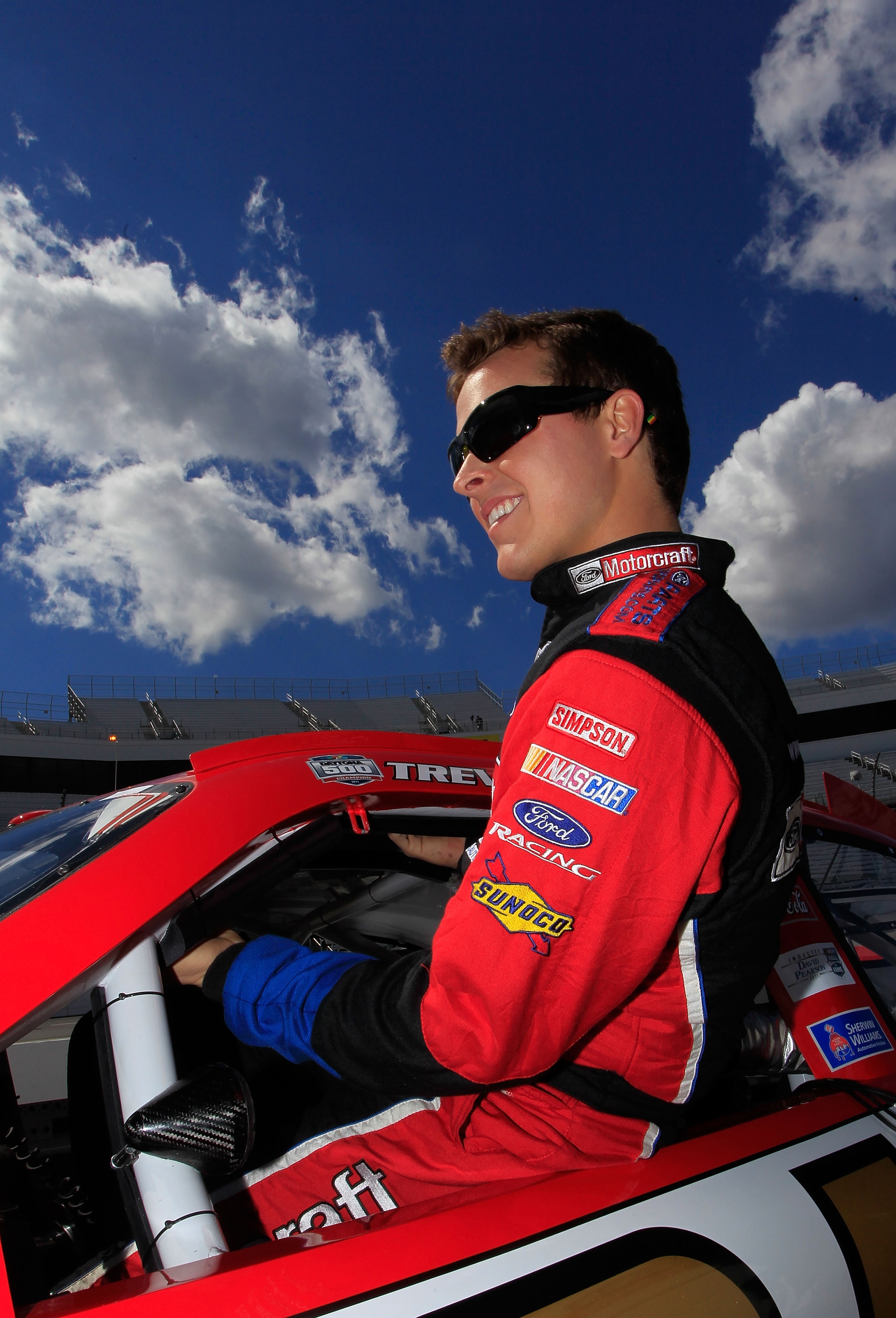 MARTINSVILLE, VA - APRIL 02:  Trevor Bayne, driver of the #21 Motorcraft/Quick Lane Tire & Auto Center Ford, climbs in his car on the grid during qualifying for the NASCAR Sprint Cup Series Goody's Fast Relief 500 at Martinsville Speedway on April 2, 2011