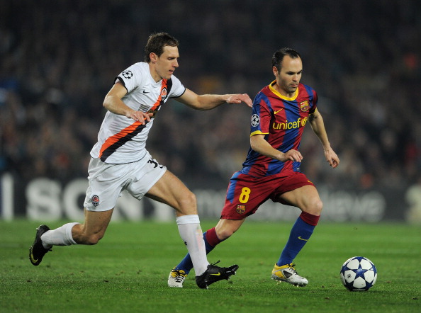 BARCELONA, SPAIN - APRIL 06:  Andres Iniesta (R) of Barcelona runs for the ball with Mykola Ishchenko of Shakhtar Donetsk during the UEFA Champions League quarter final first leg match between Barcelona and Shakhtar Donetsk at the Camp Nou stadium on Apri