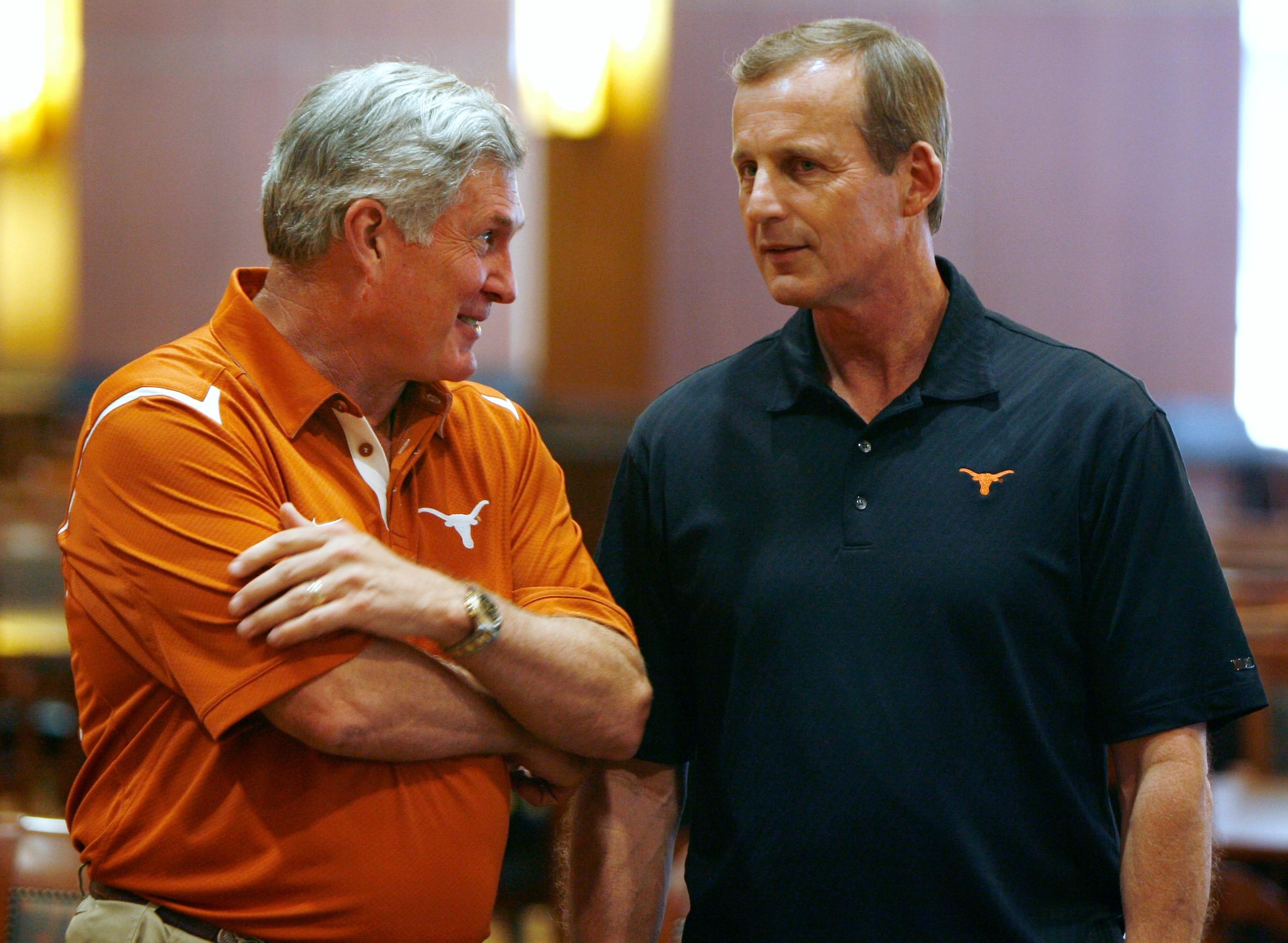 AUSTIN, TX - JUNE 15:  University of Texas at Austin football head coach Mack Brown, left, and men's head basketball coach Rick Barnes talk before a press conference in which university officials announce the athletics programs will continue competing in